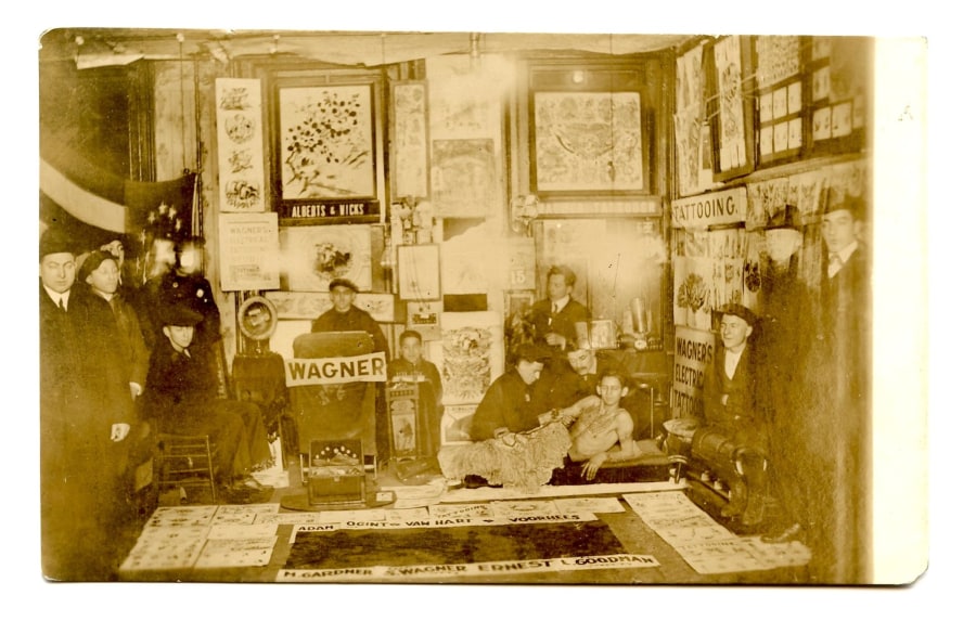 A black-and-white photo of a man's back, tattooed with an image of angels.