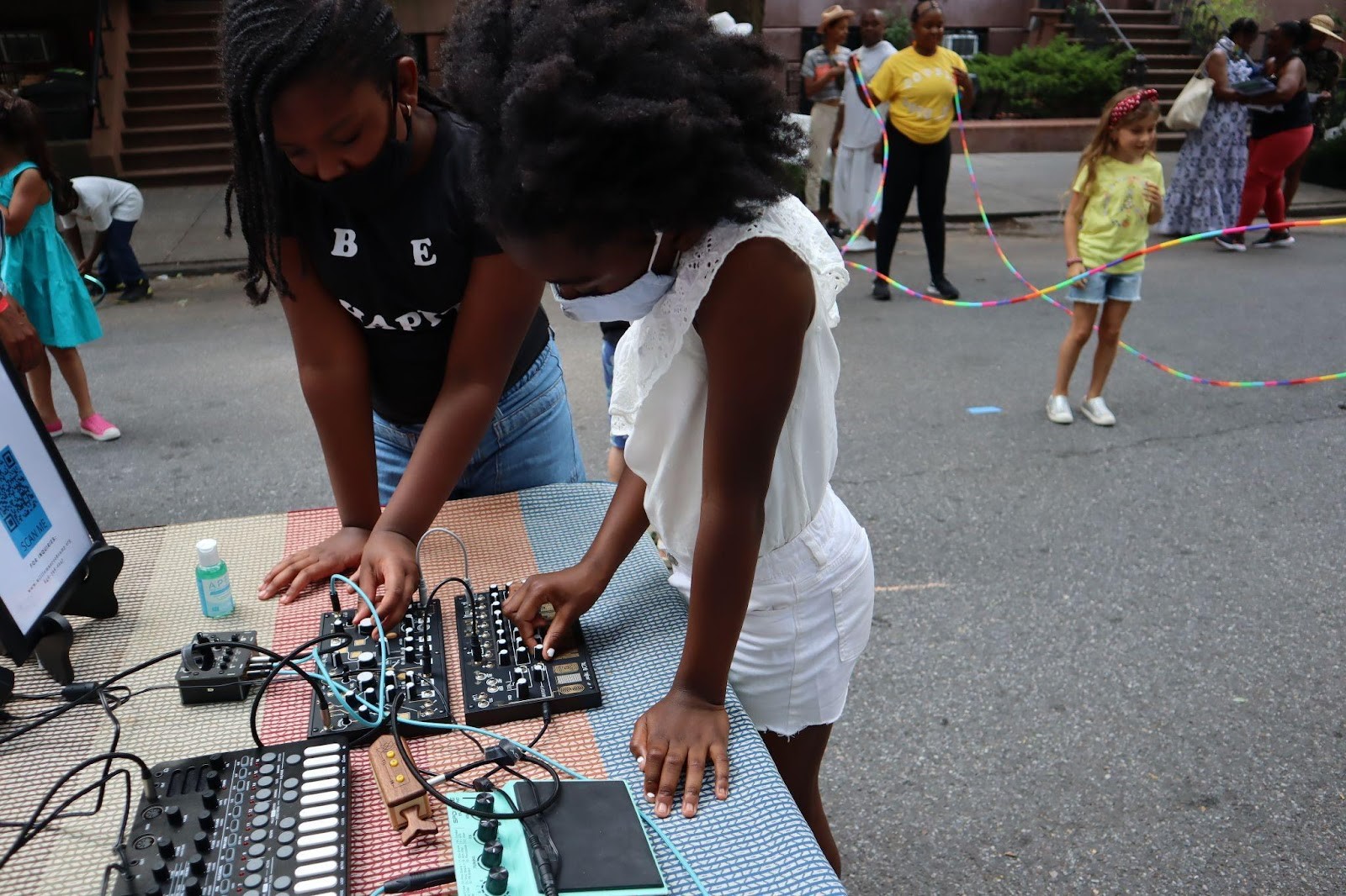 An image of two women standing over a table filled with audio equipment