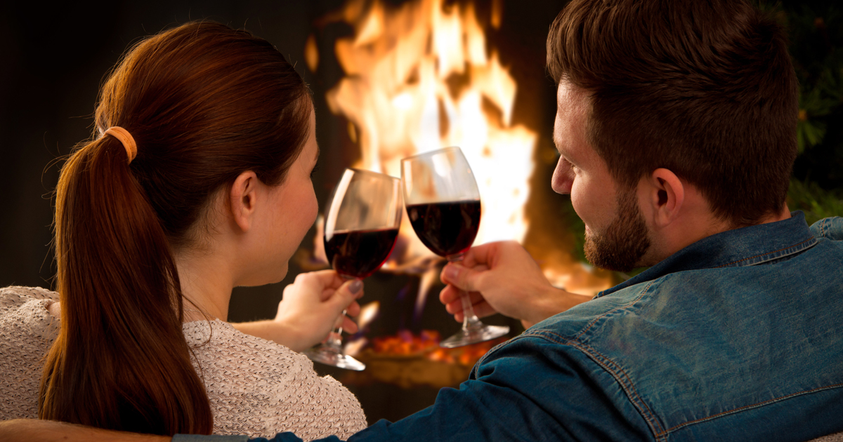 A couple drinking wine in front of a fire A couple drinking wine in front of a fire