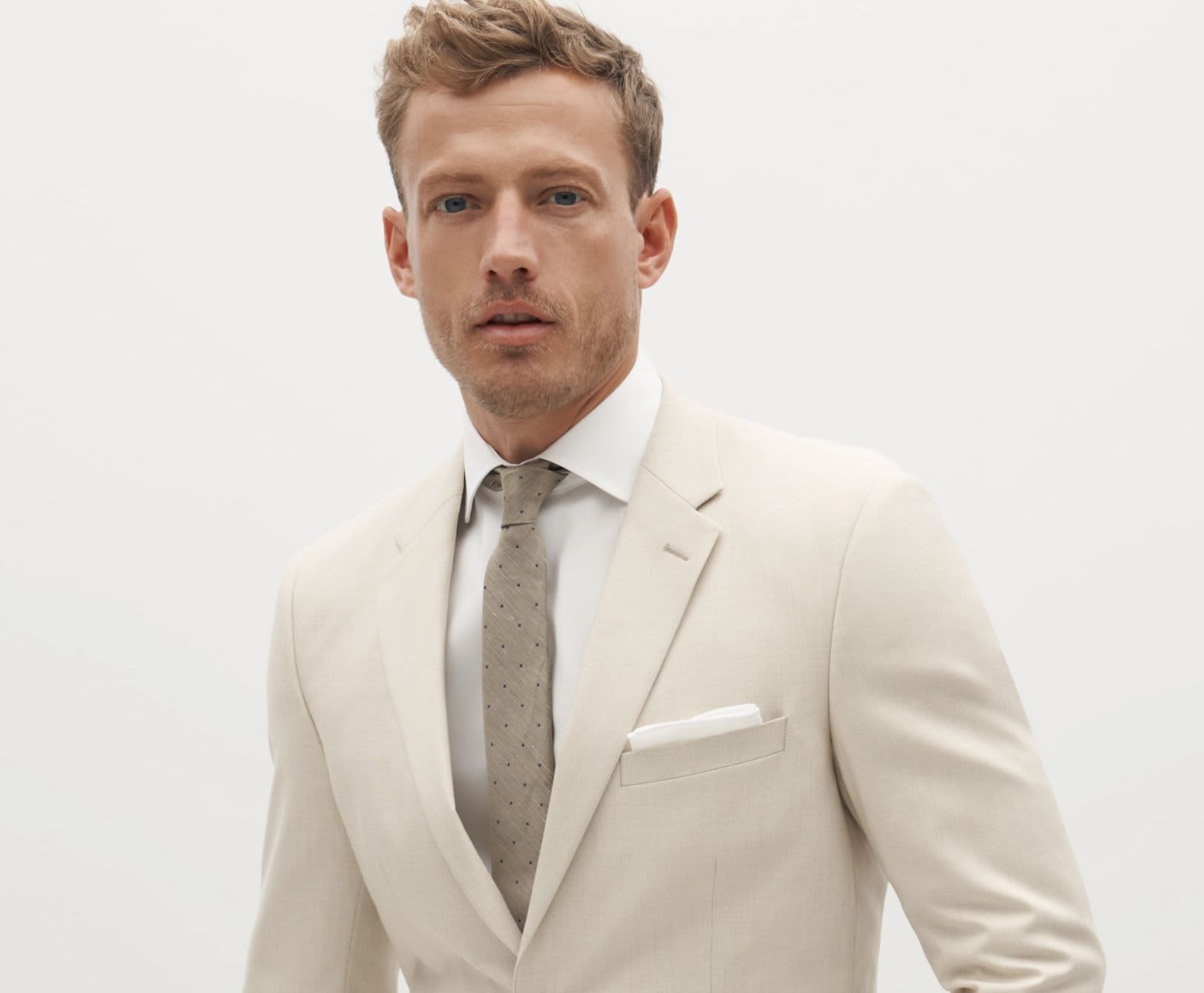 Professional man dressed in modern dark green suit and simple white button down shirt.