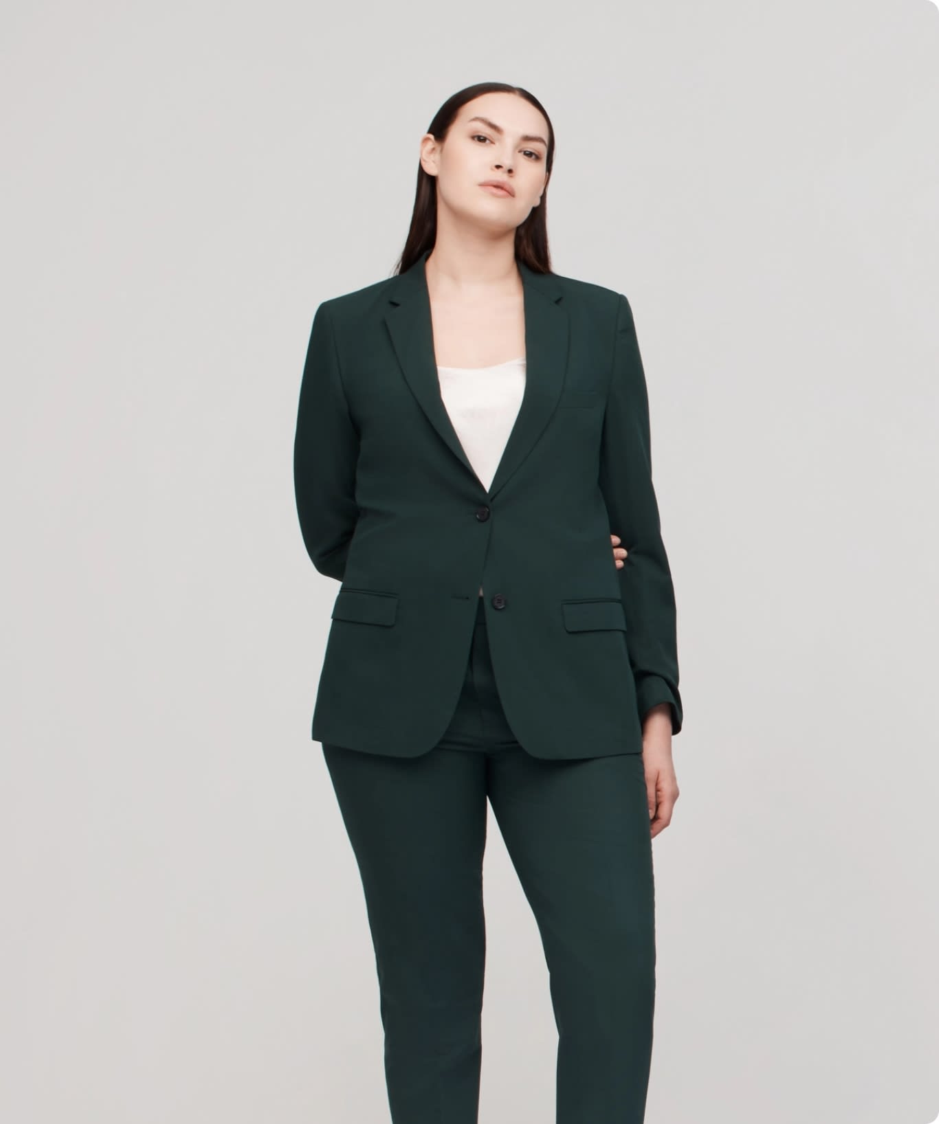 Professional woman in corporate workwear, a dark green suit