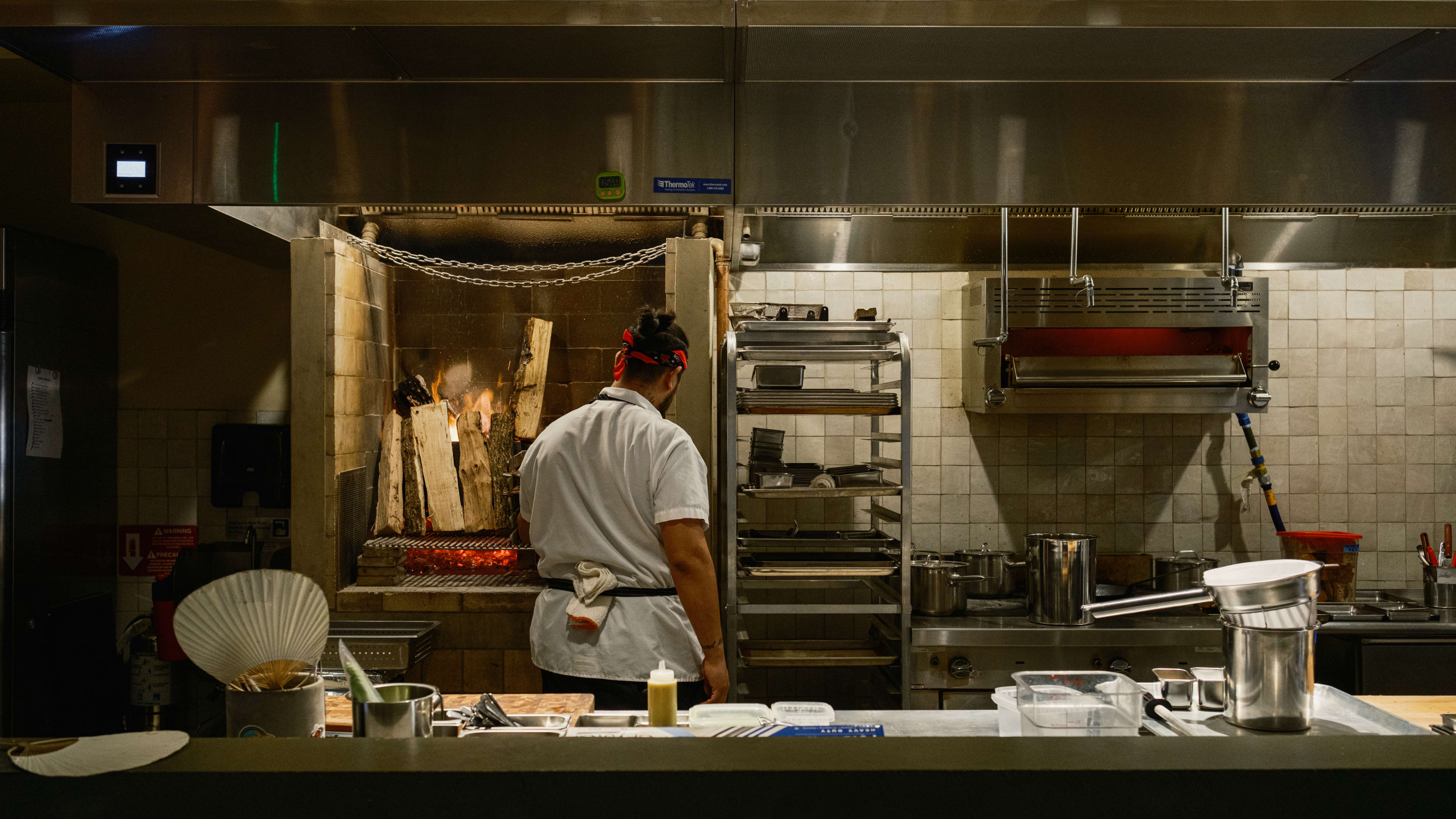 open kitchen at Baso with a chef cooking in front of an open flame