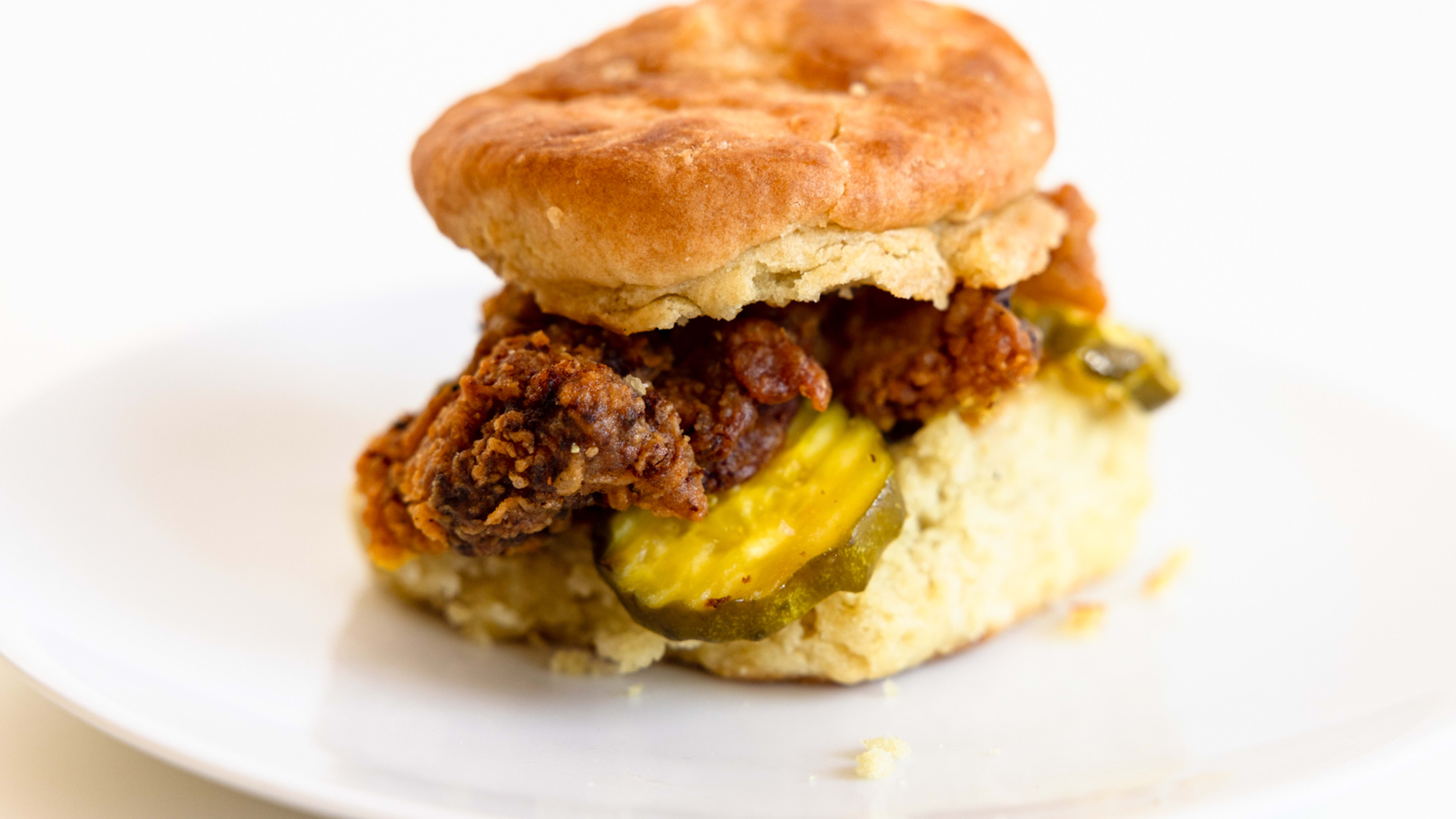 Biscuit with fried chicken and pickles.