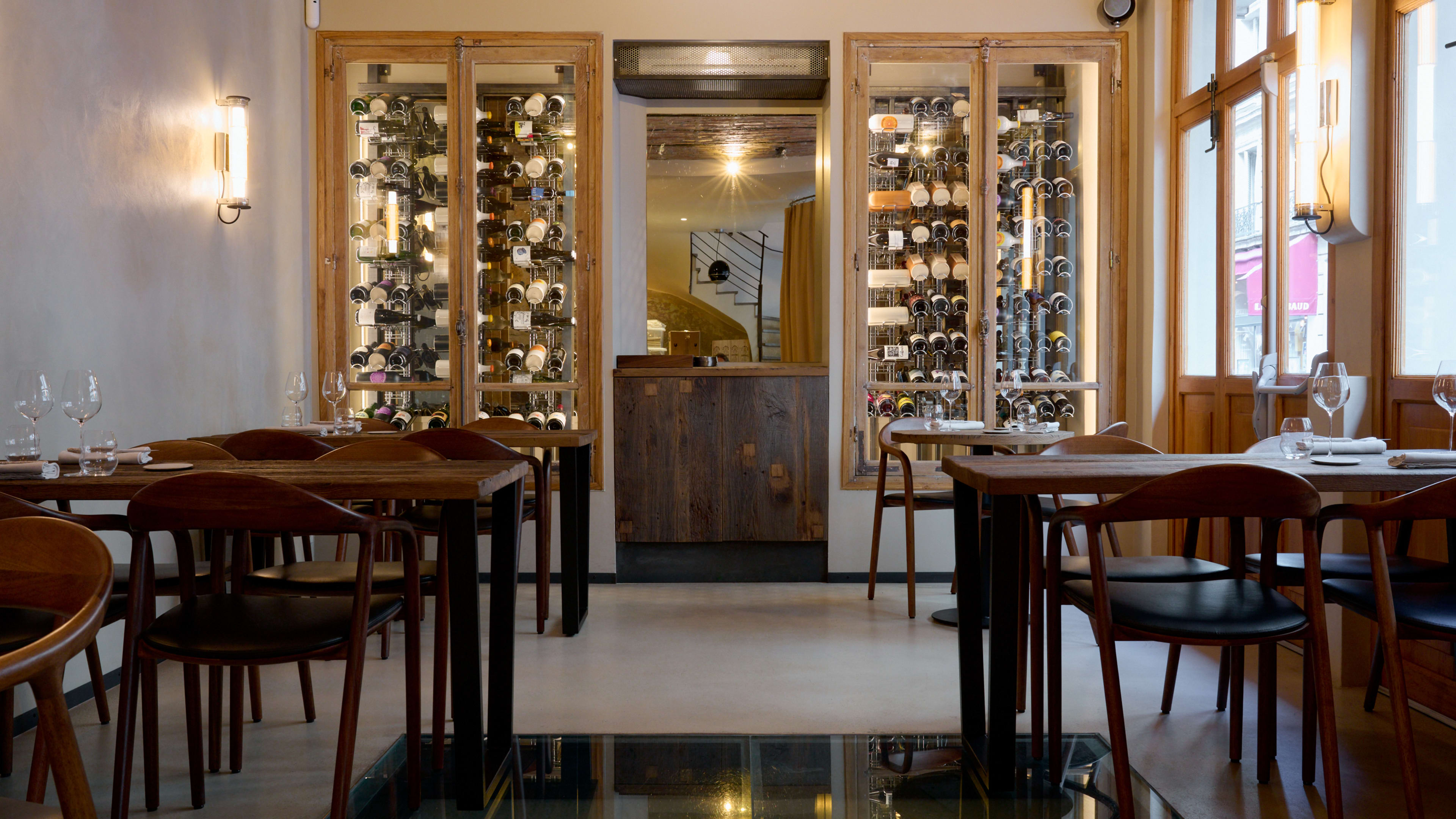 Bright interior dining room with racks of wine bottles at Géosmine