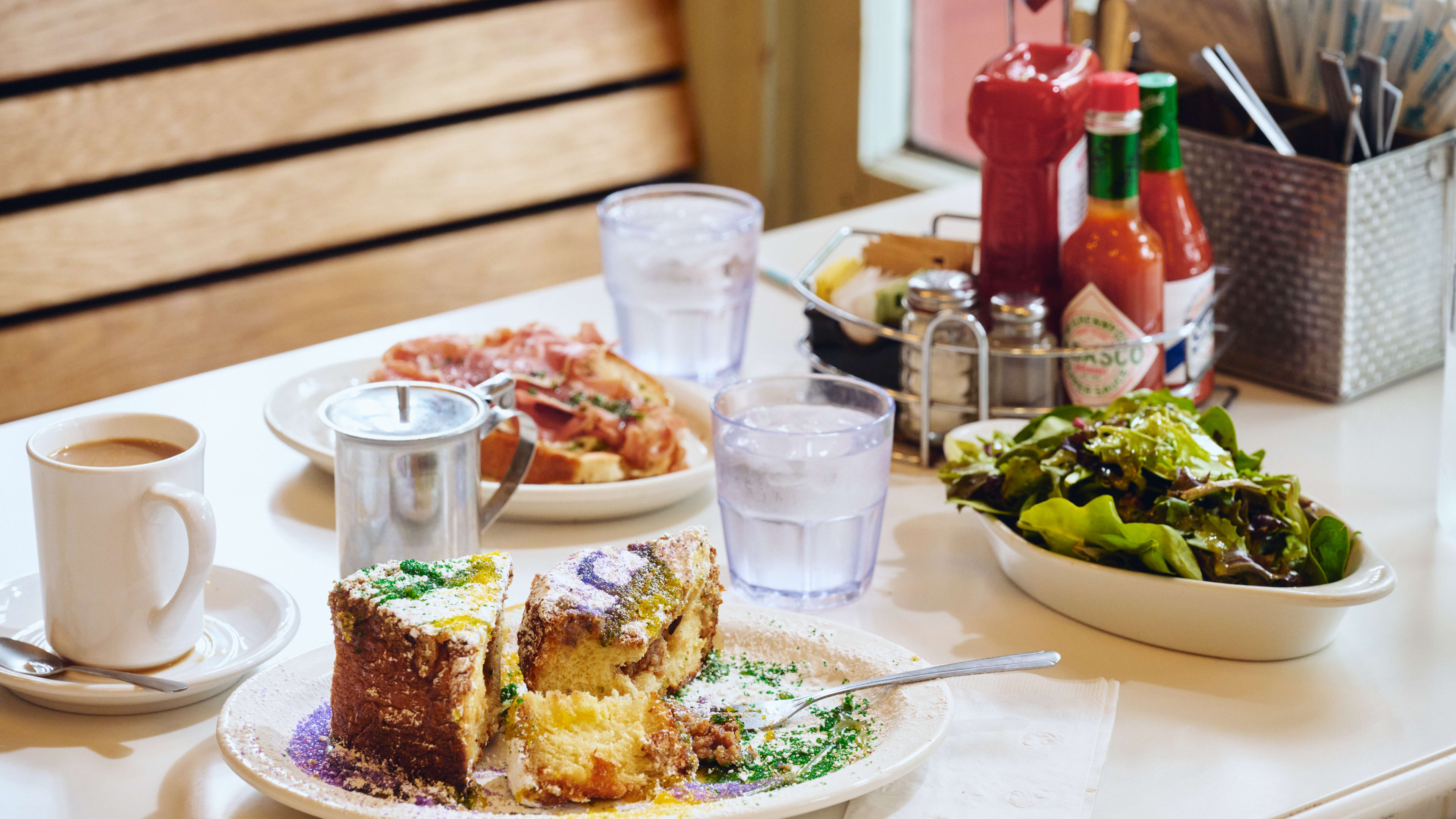 Spread of breakfast dishes including Mardi Gras French toast at Toast