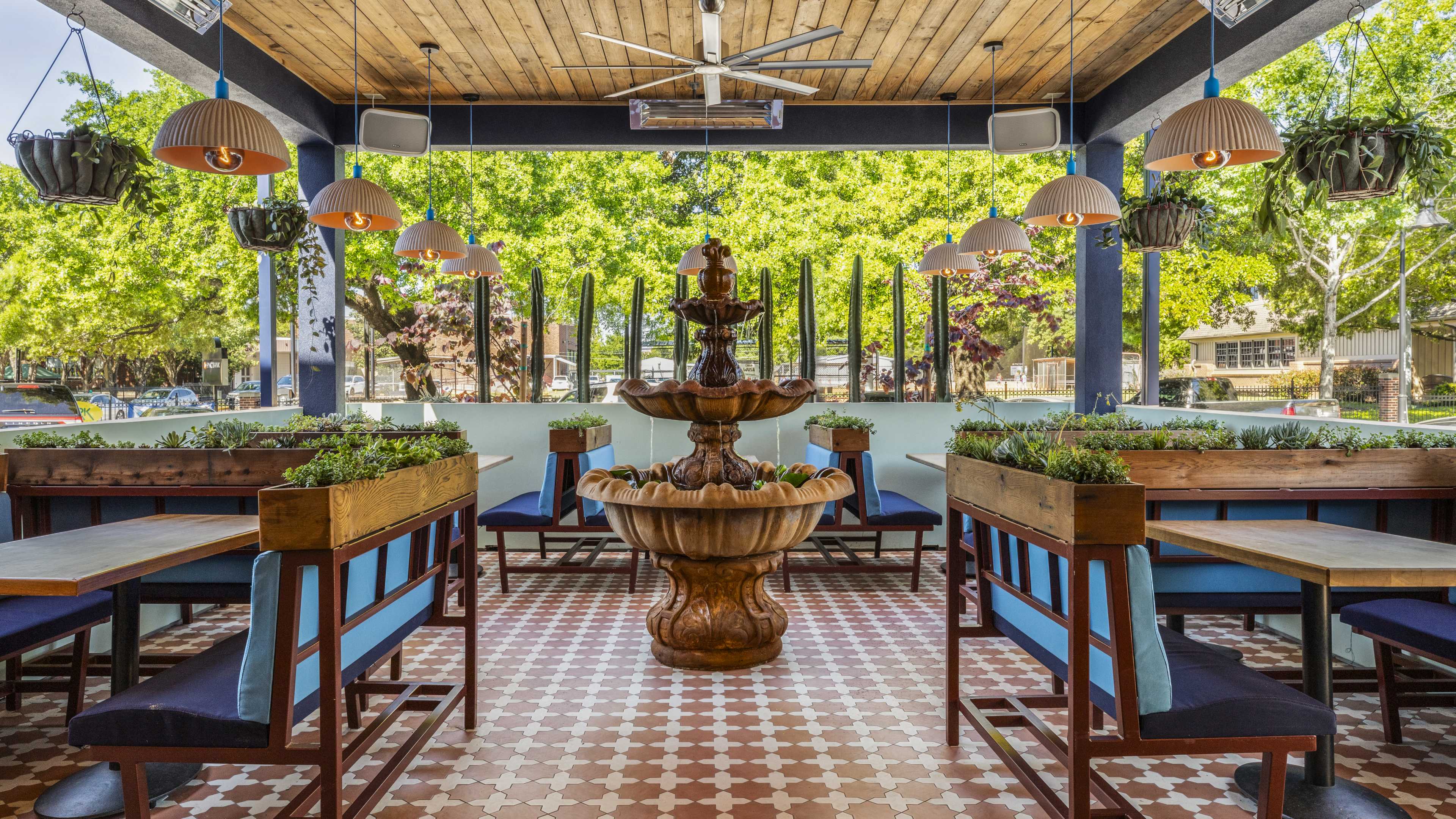 colorful, tiled patio of Maximo Canteen with a large, Spanish-style tiered concrete fountain the center