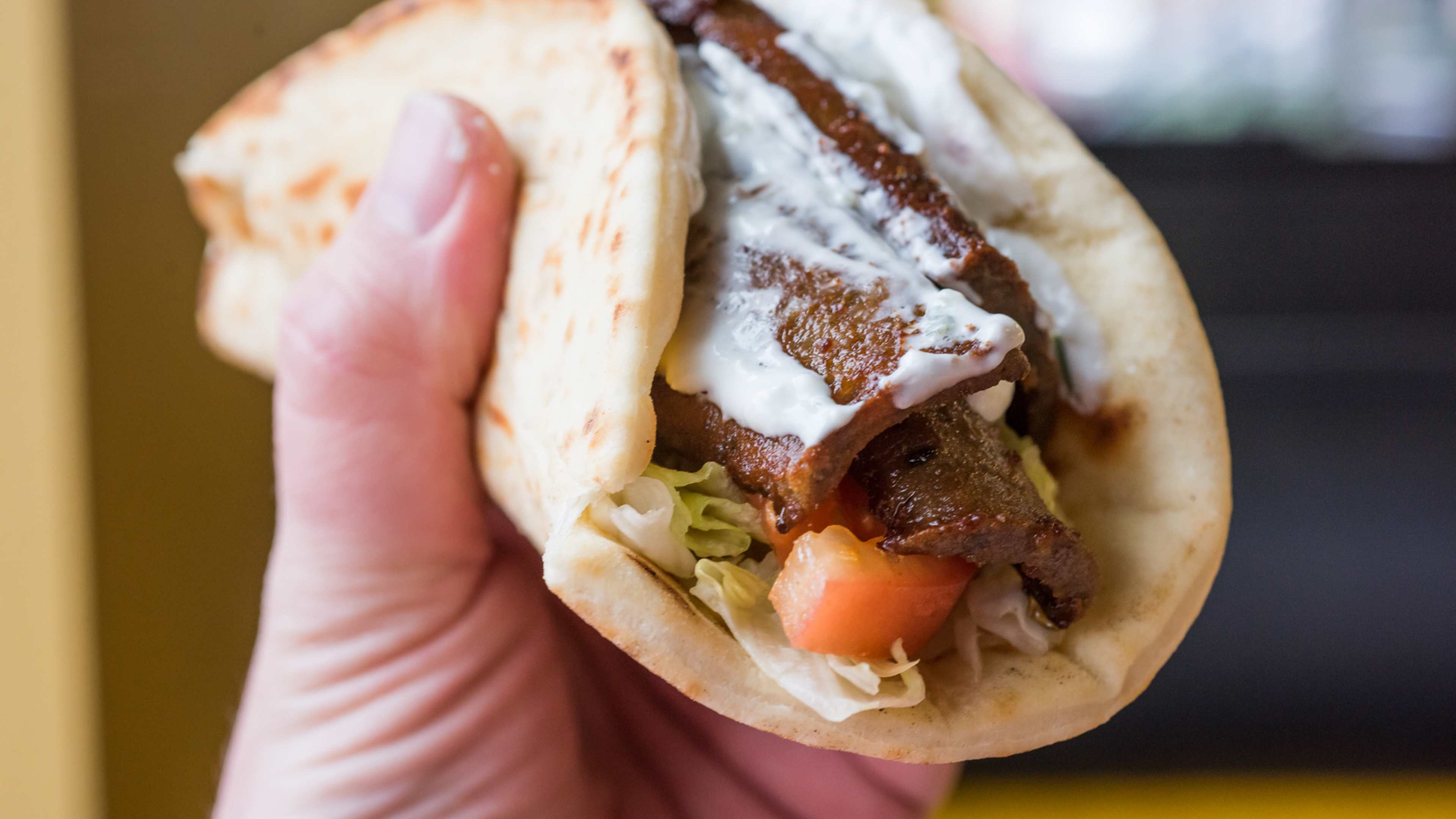 hand holding lamb and beef gyro