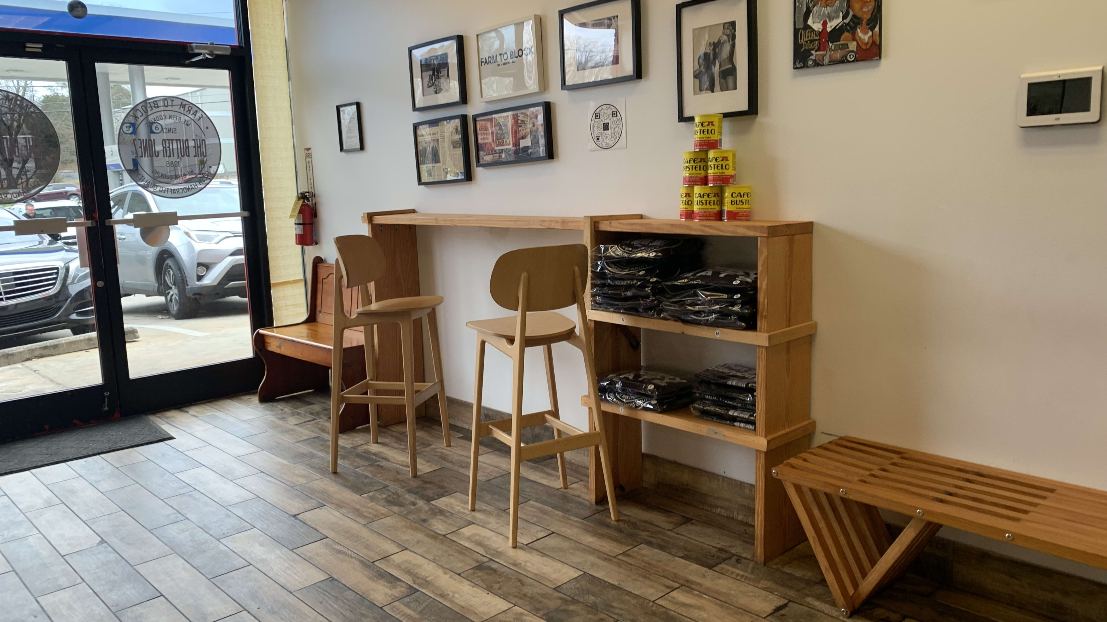 Wooden floors with small bench and photos on the wall.