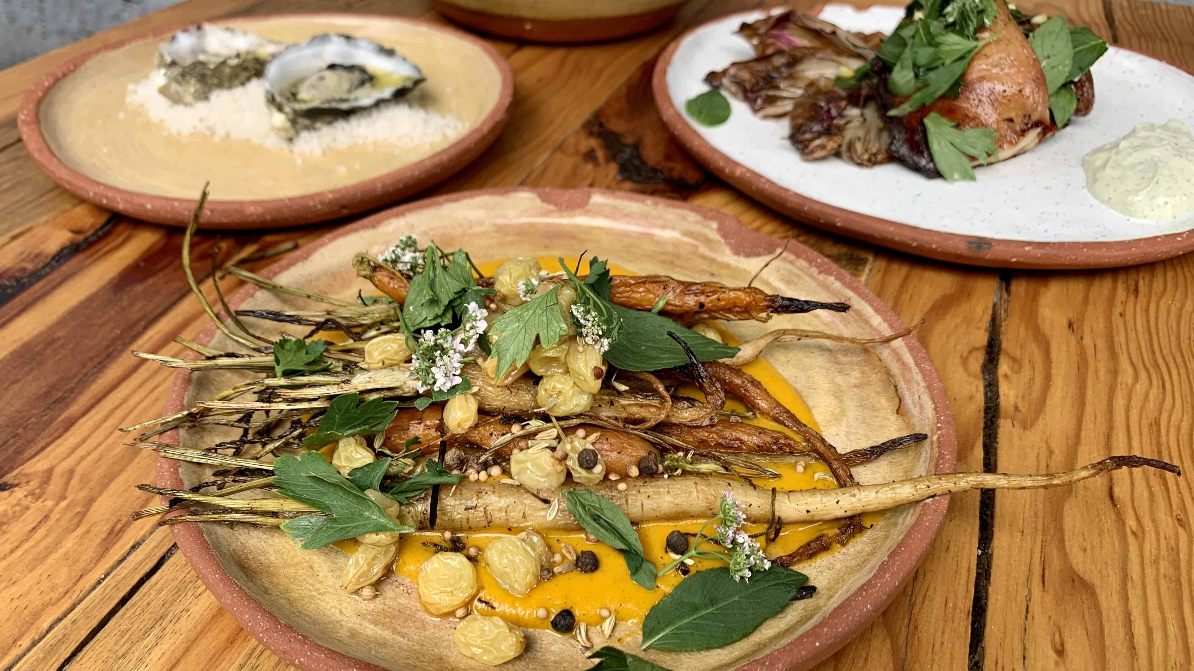 Roasted carrots an other vegetables on a wooden table at Marmota, a restaurant in Mexico City