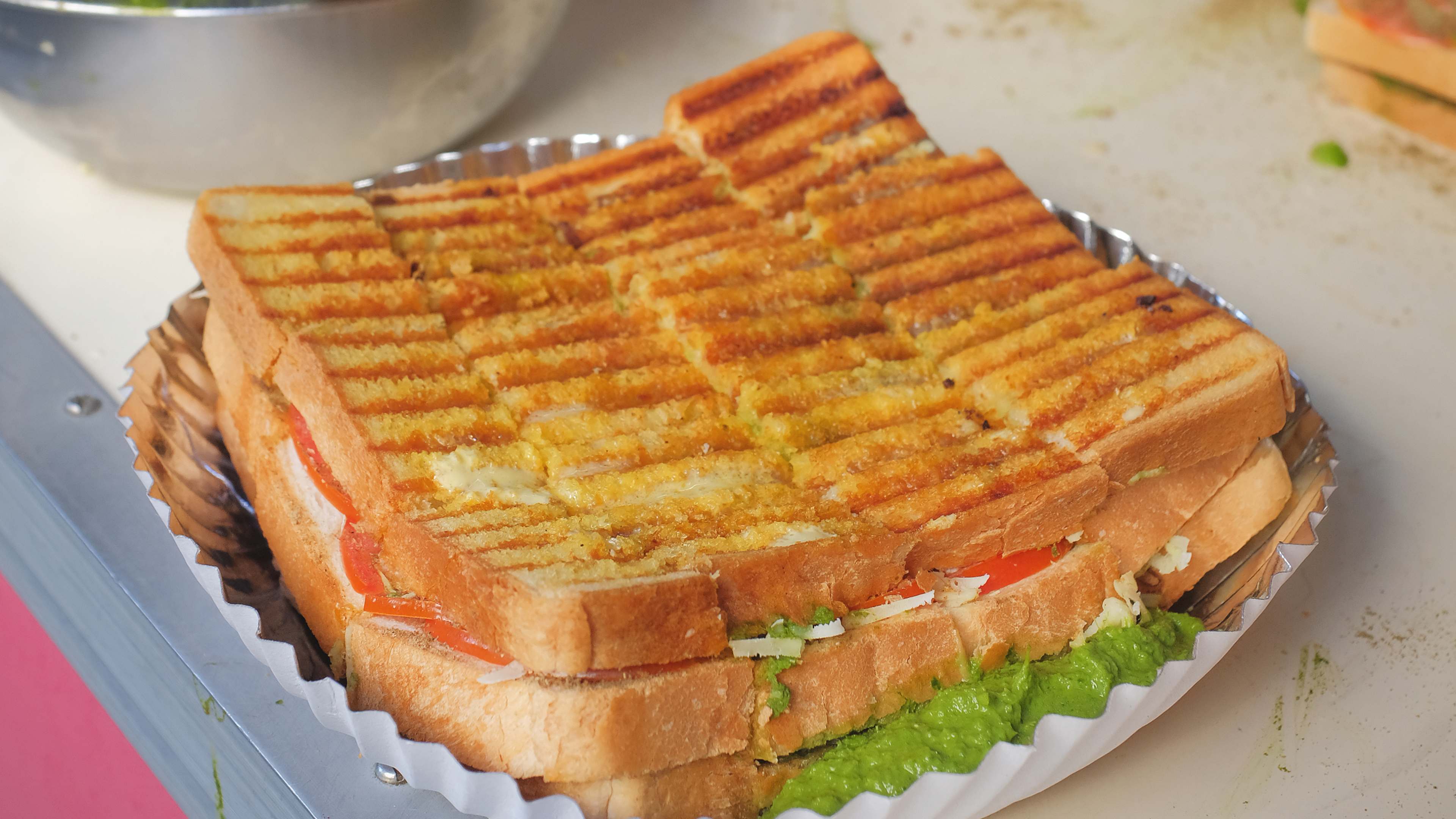 Grilled Bombay sandwich on paper plate at Anand Stall