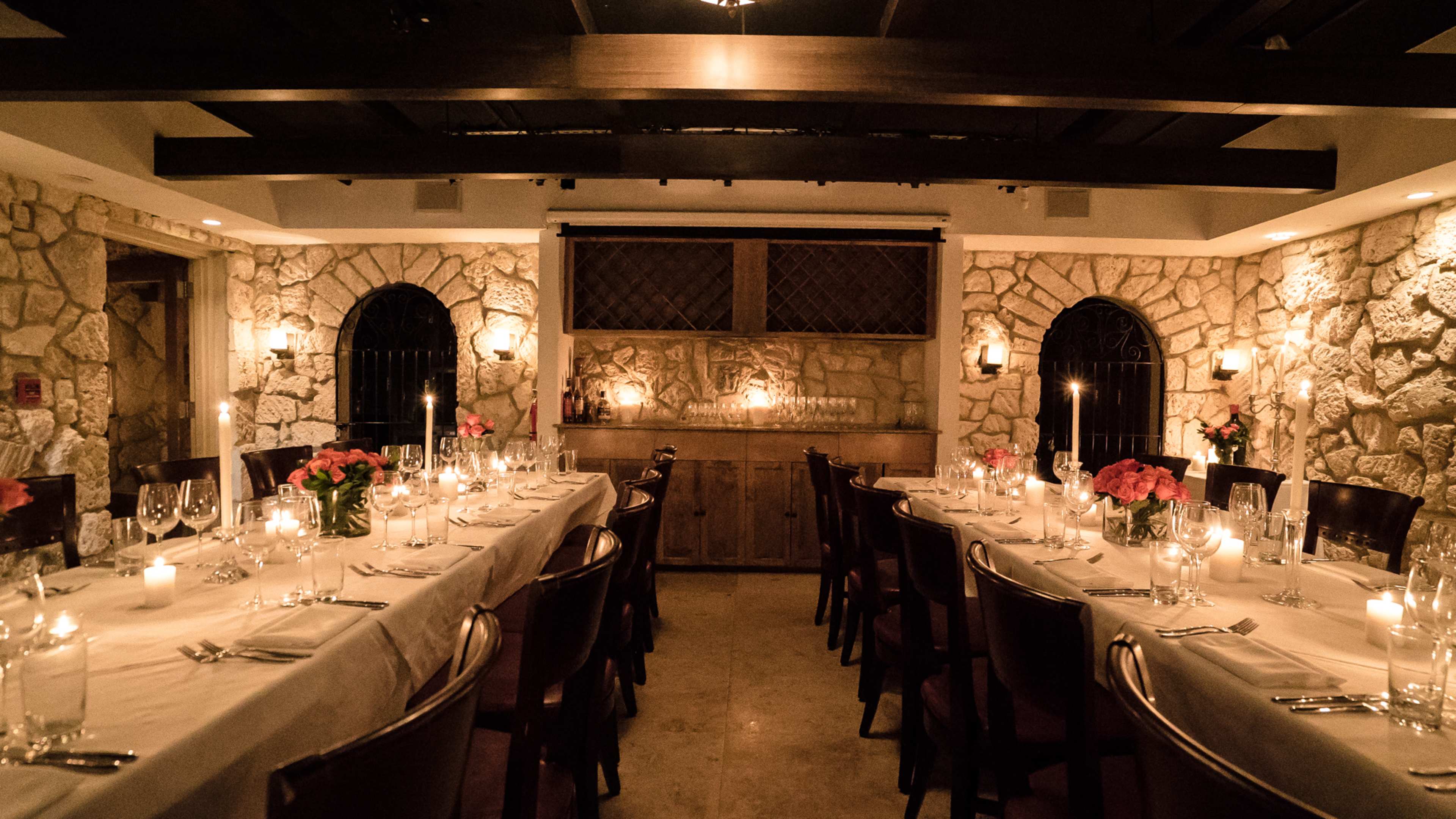 A private dining room with candles and stone walls.