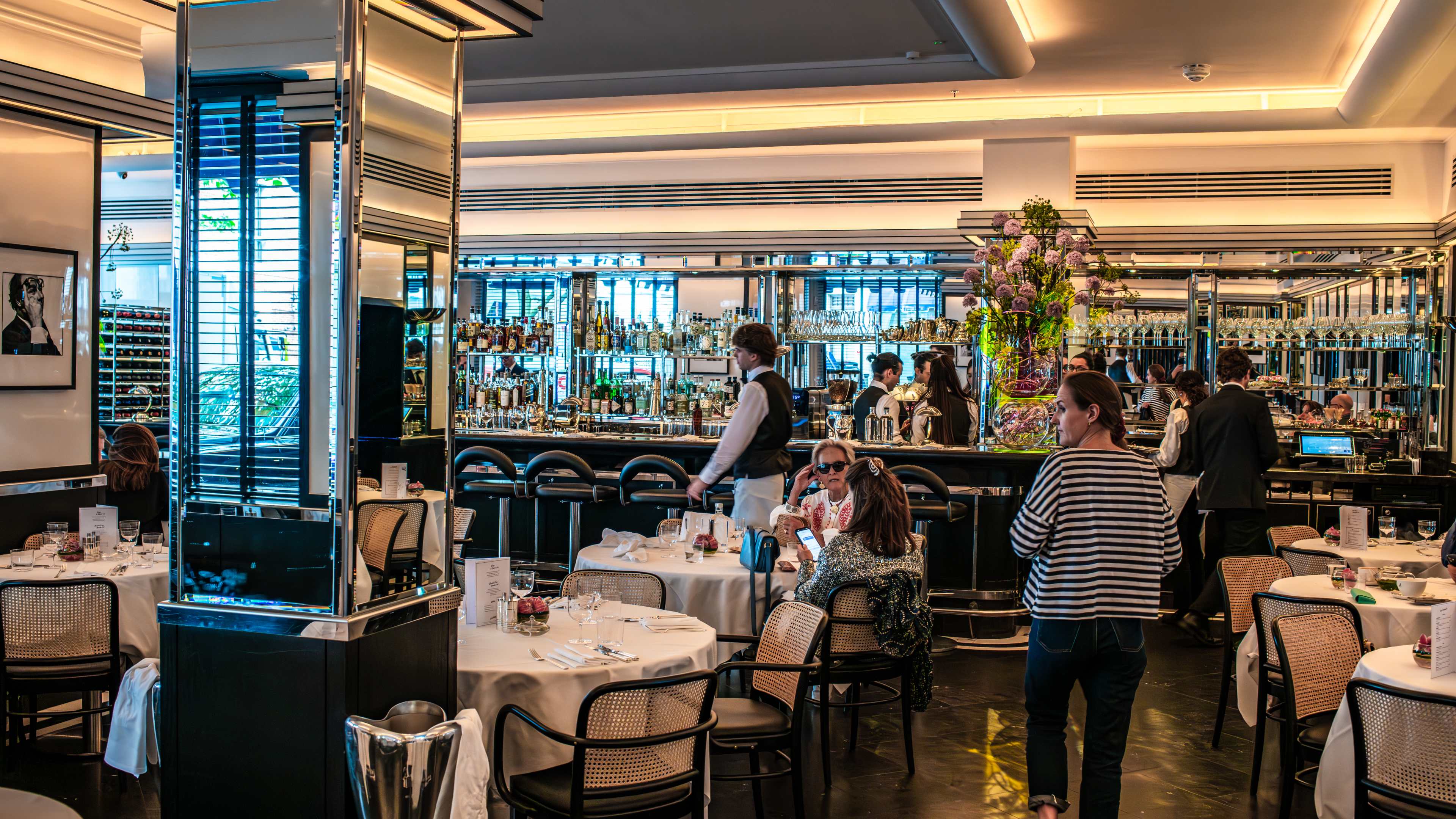 The dining room and bar at Arlington. There are mirrors covering most of the walls and columns.