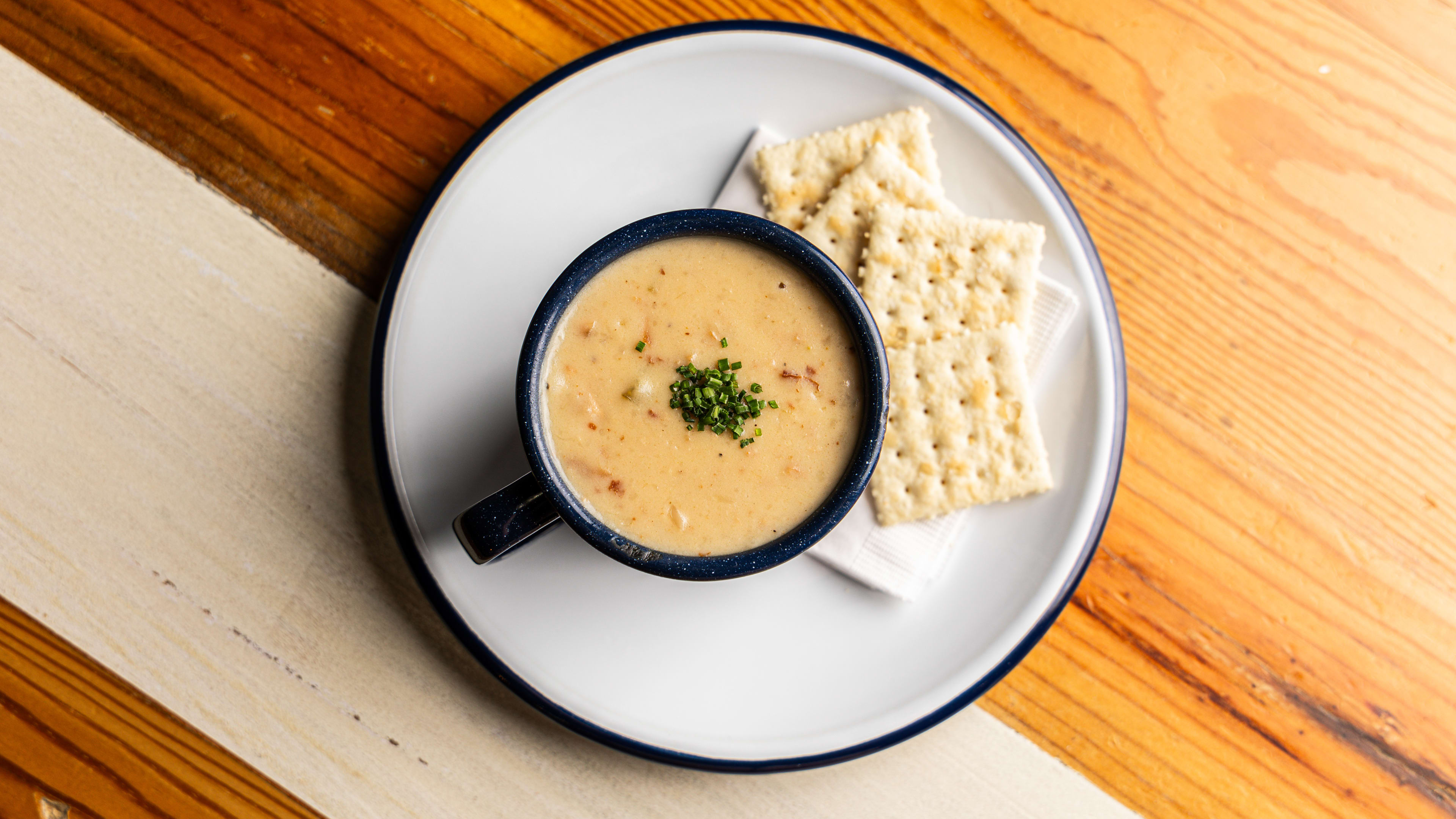 A mug of chowder and saltine crackers.