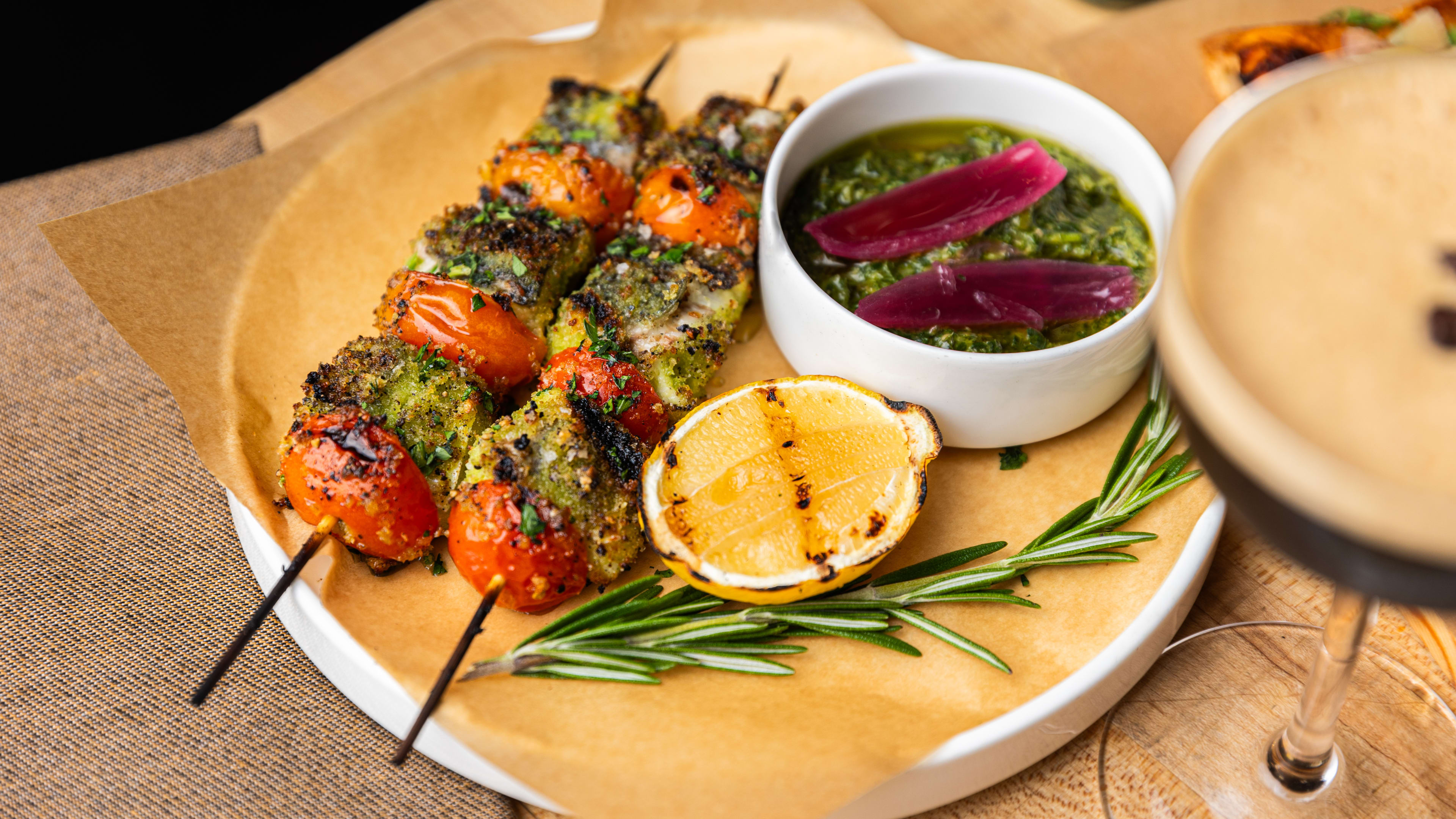 Veggie and chicken skewers with a side of chimichurri sauce.