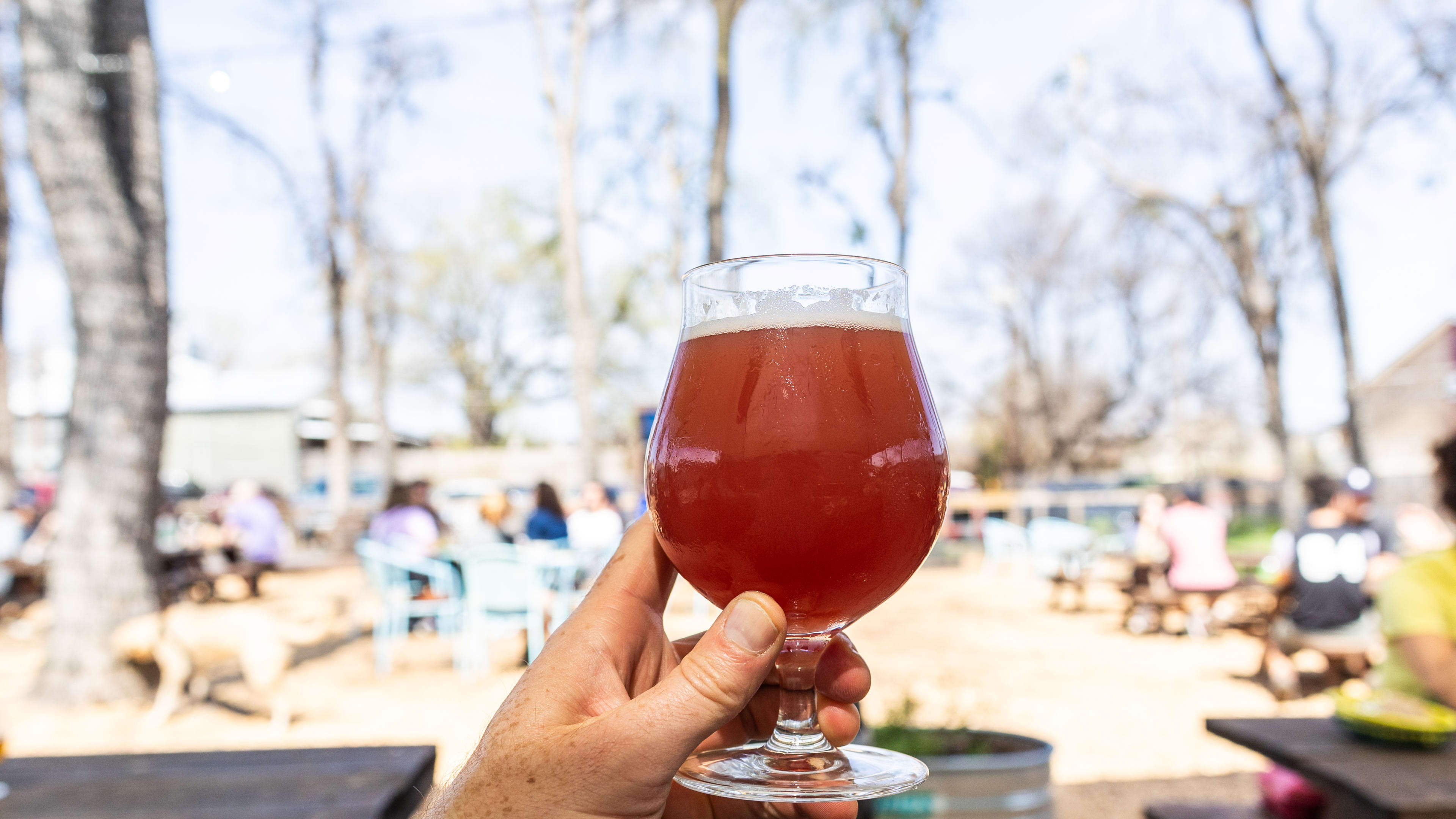 The Kolache Bier held up against the bustling exterior seating area at Batch Brewing.