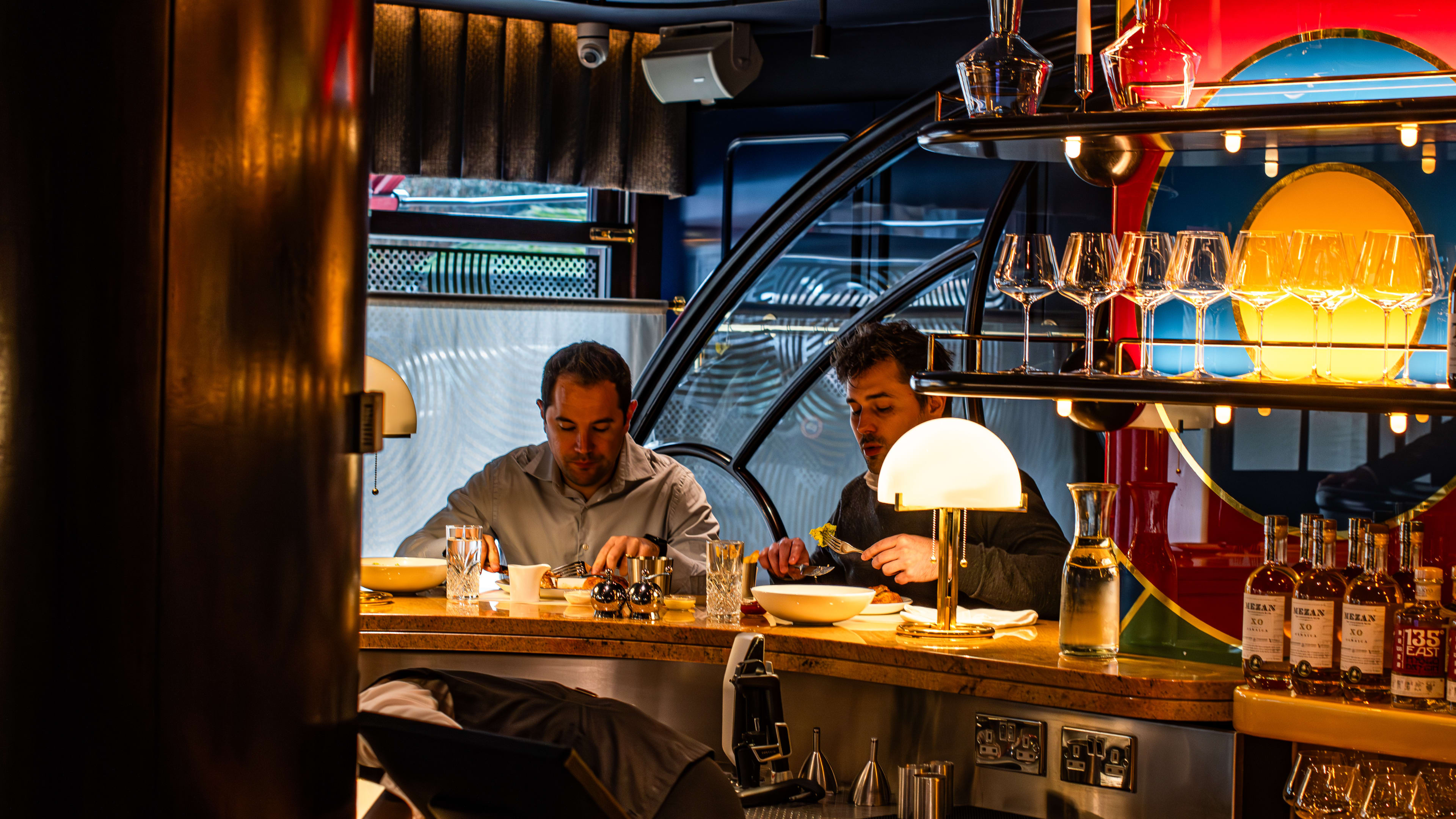 Two people eating a meal at the golden bar at Bebe Bob.