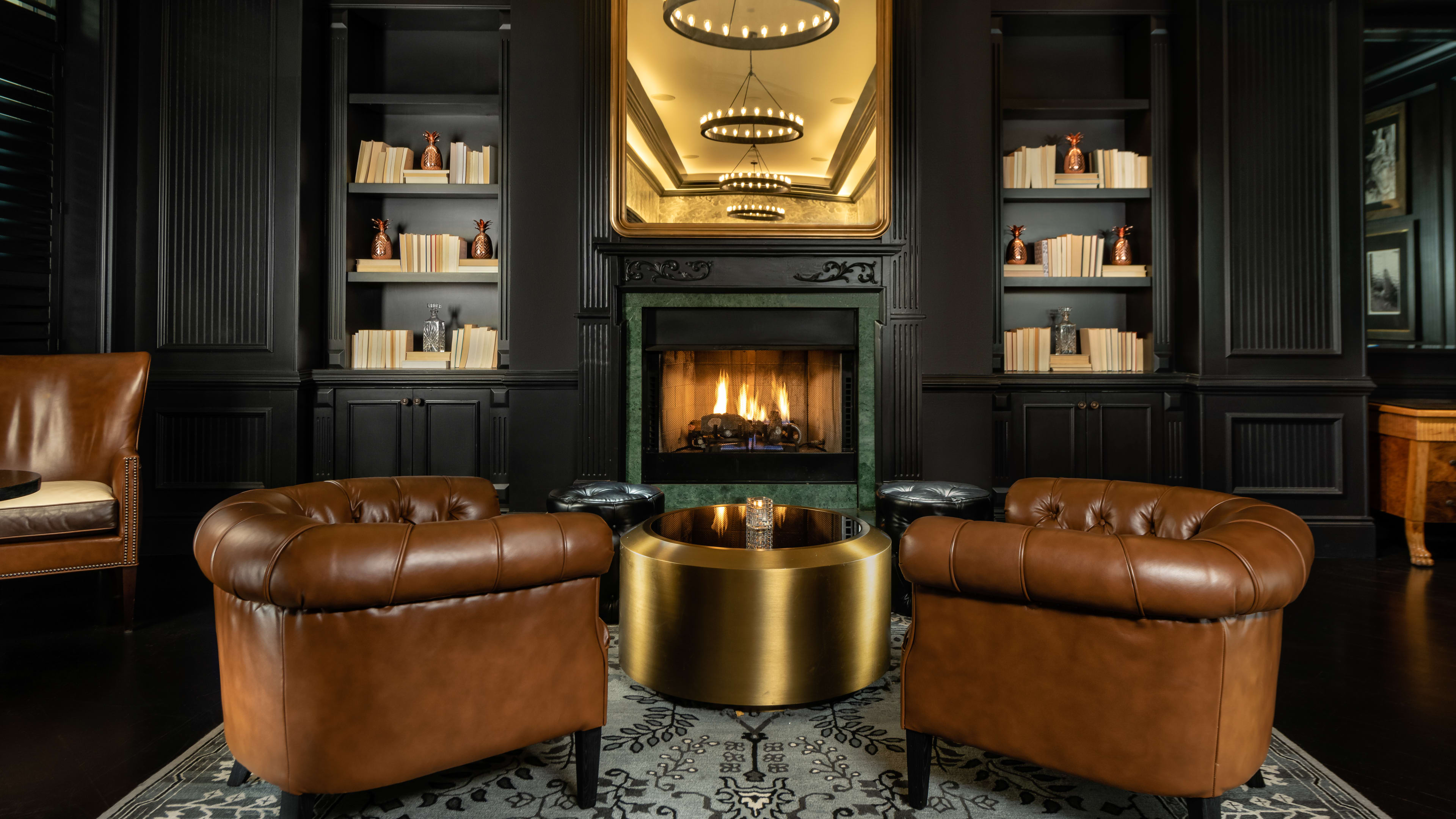 The Commodore Bar with a lit fireplace and leather chairs