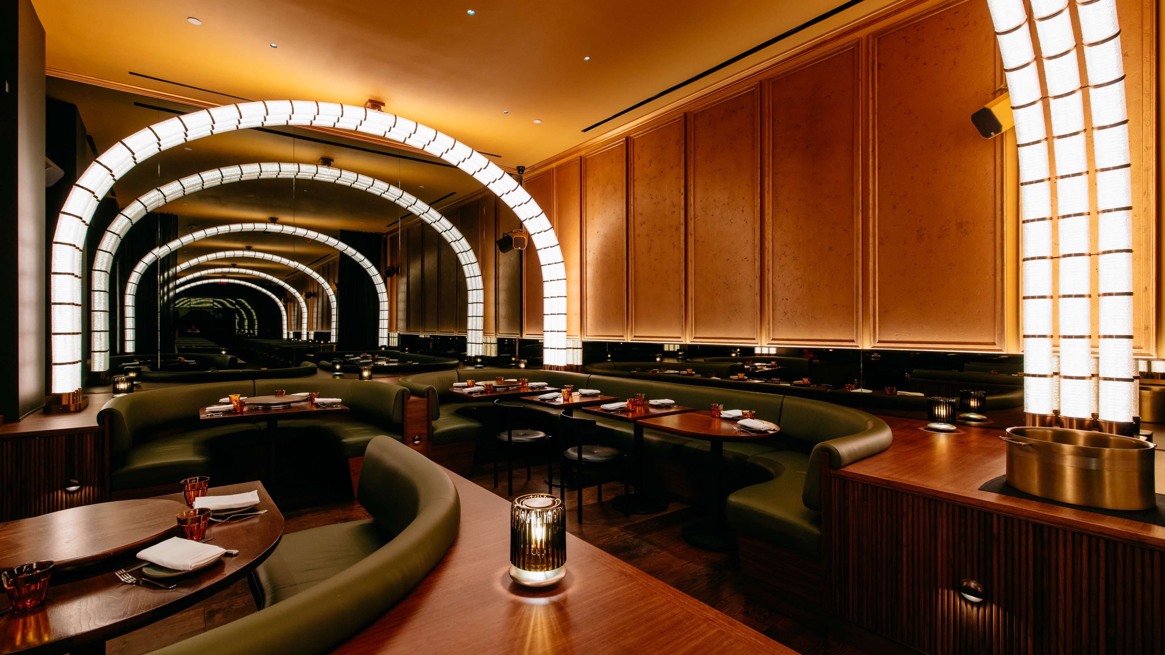 A modern dining room lined with glowing arches.