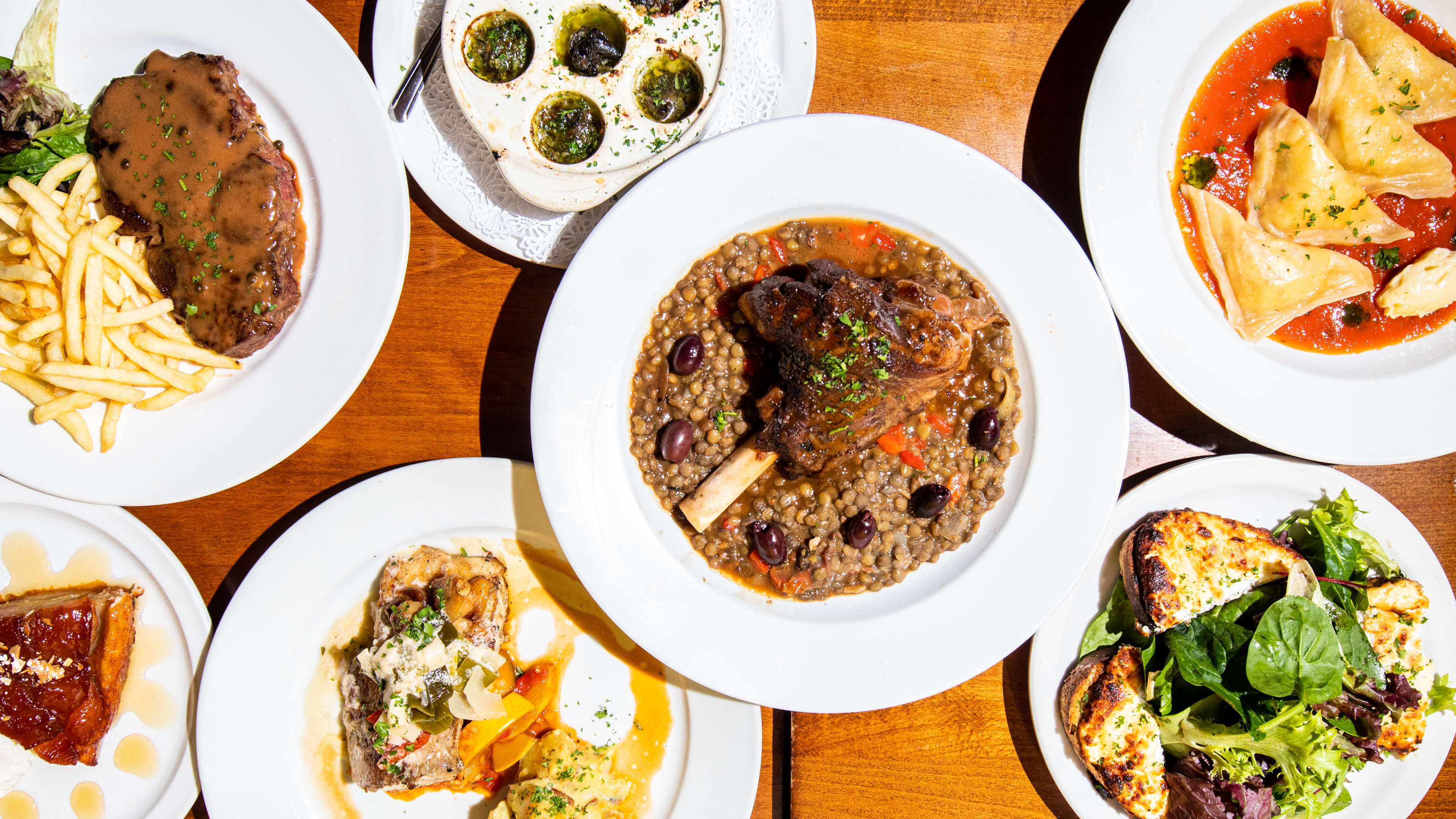 An overhead shot of a table full of dishes from Cafe Pastis.