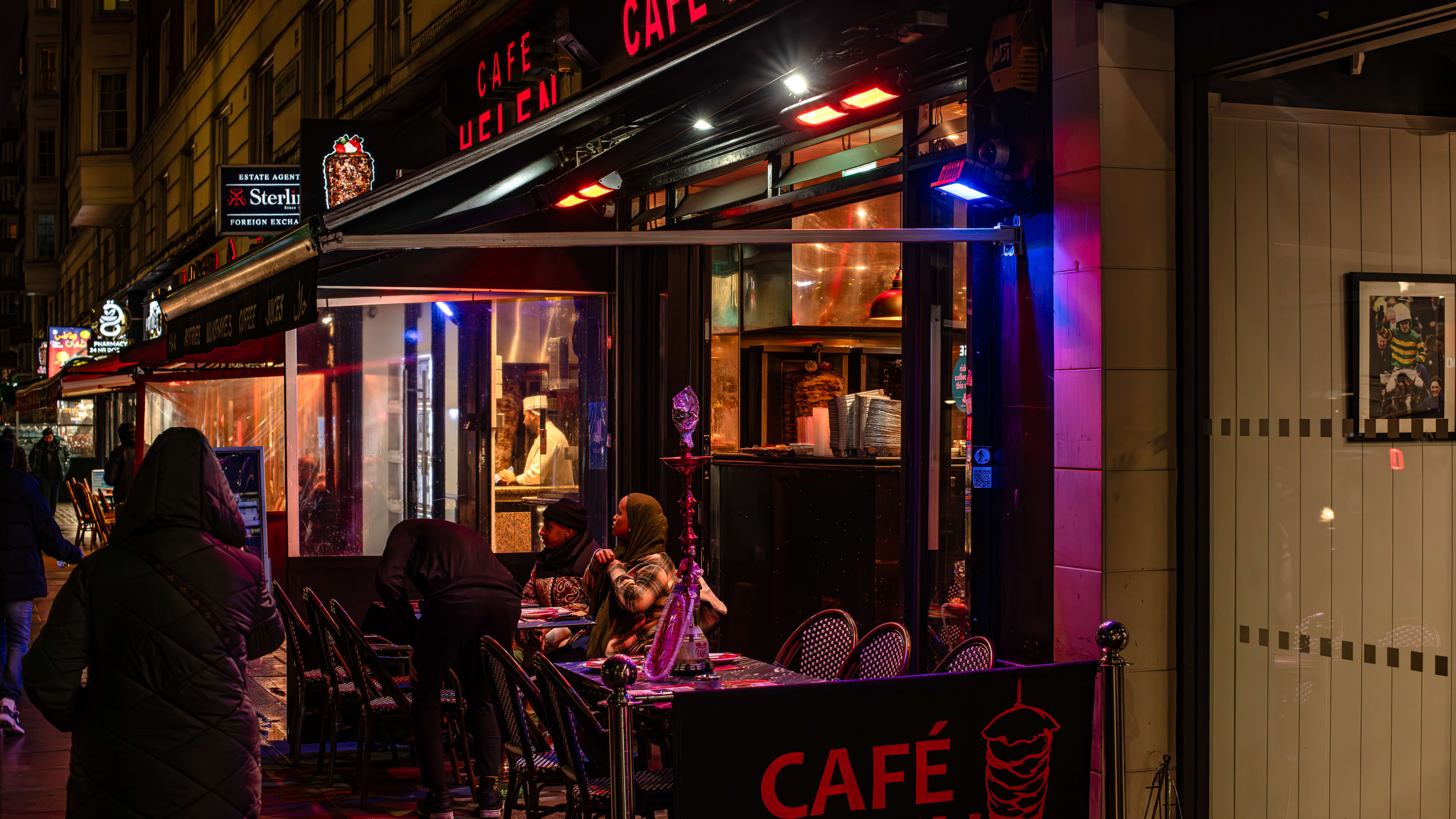 The exterior of Cafe Helen with people at small tables