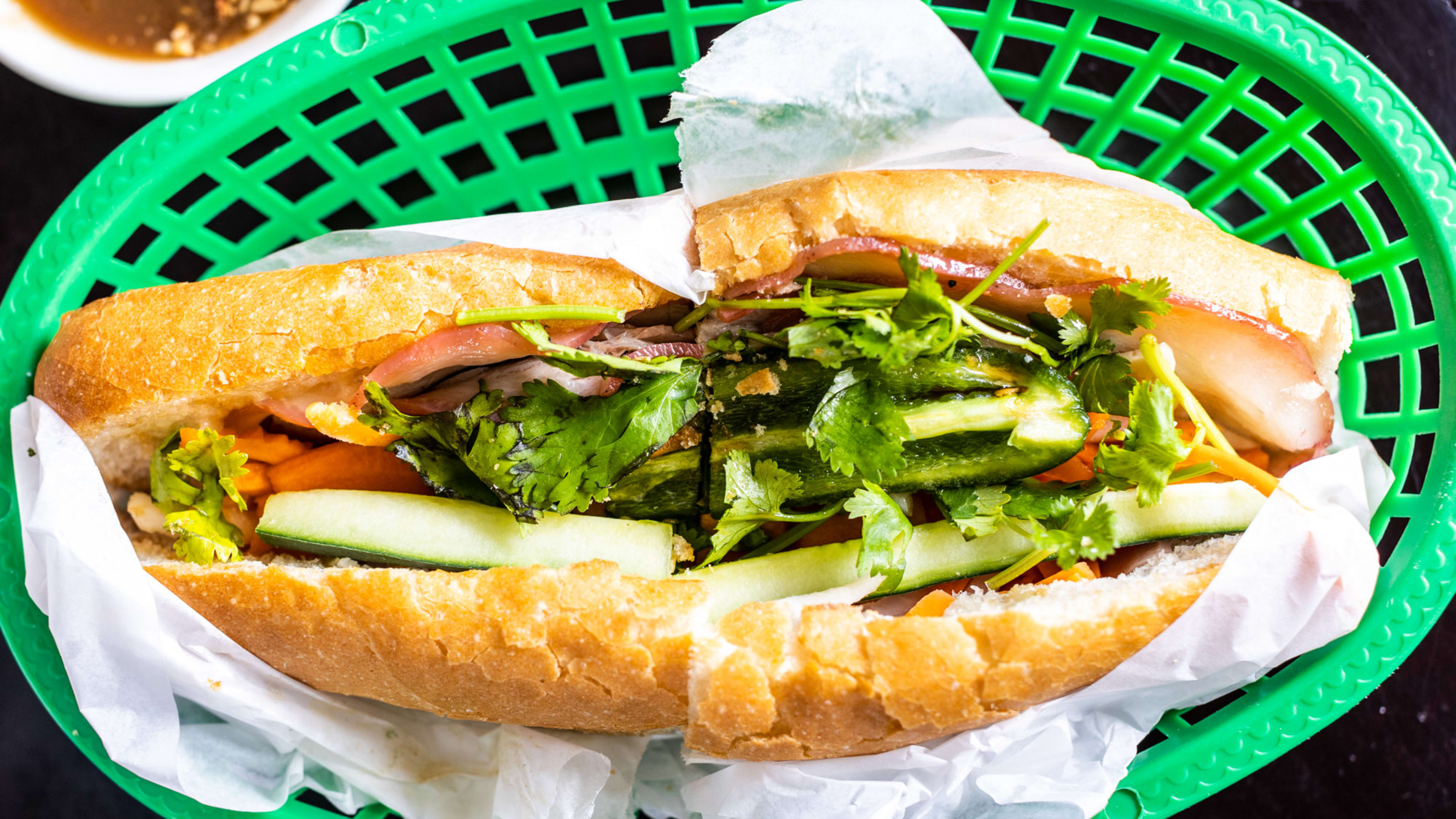 The Cali Combination banh mi from Cali Sandwiches & Pho served in a green basket.