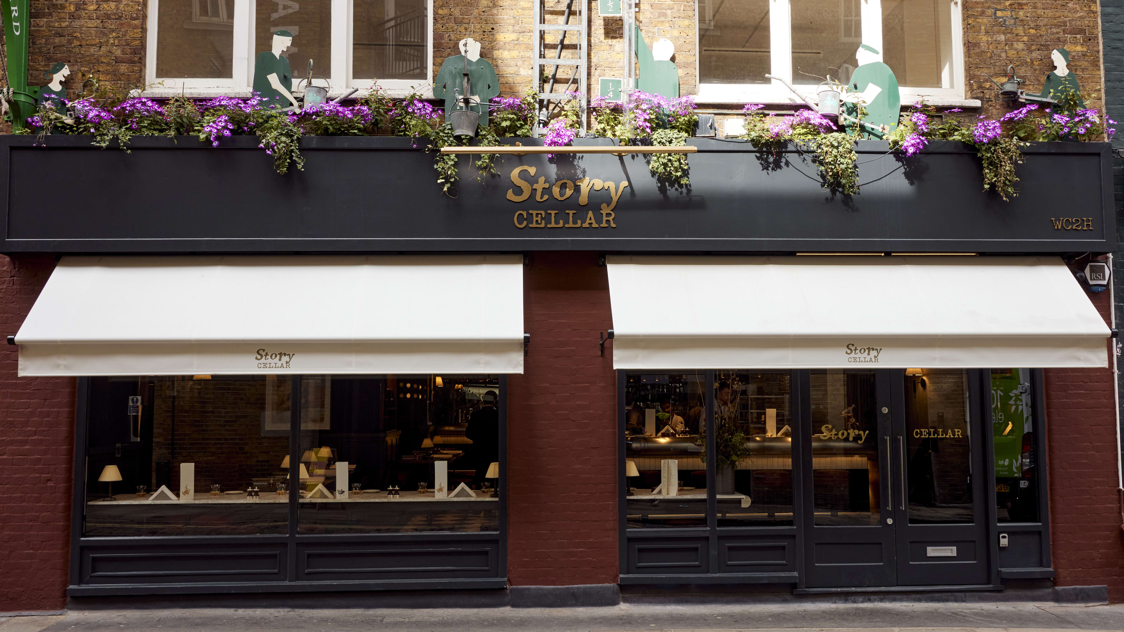 Restaurant exterior with white awnings and 'Story Cellar' written above.