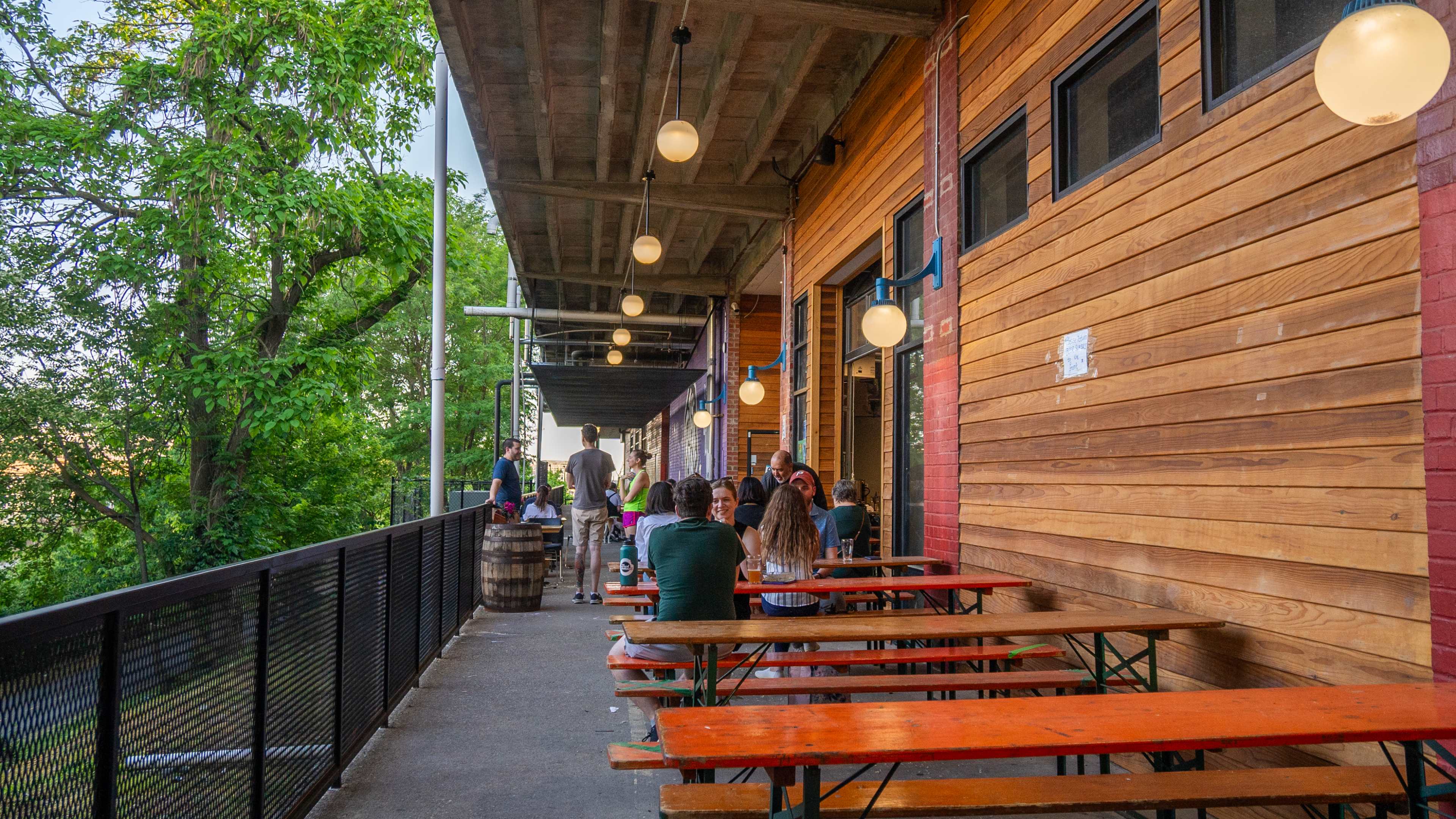 brewery patio with folks sitting at picnic tables and lots of surrounding trees