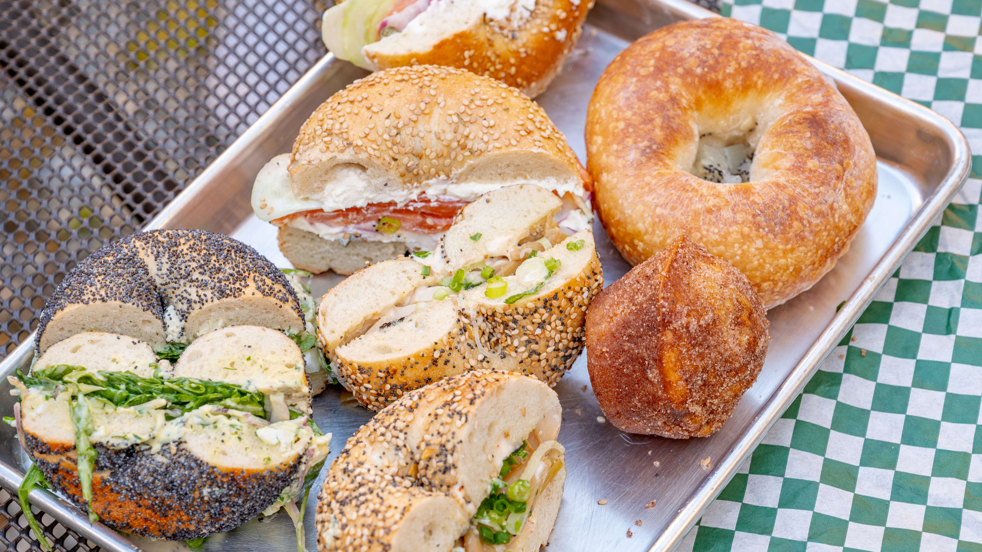 This is a bagel spread from Cleo Bagels including a ramen sandwich, bialys, and apple pastries.