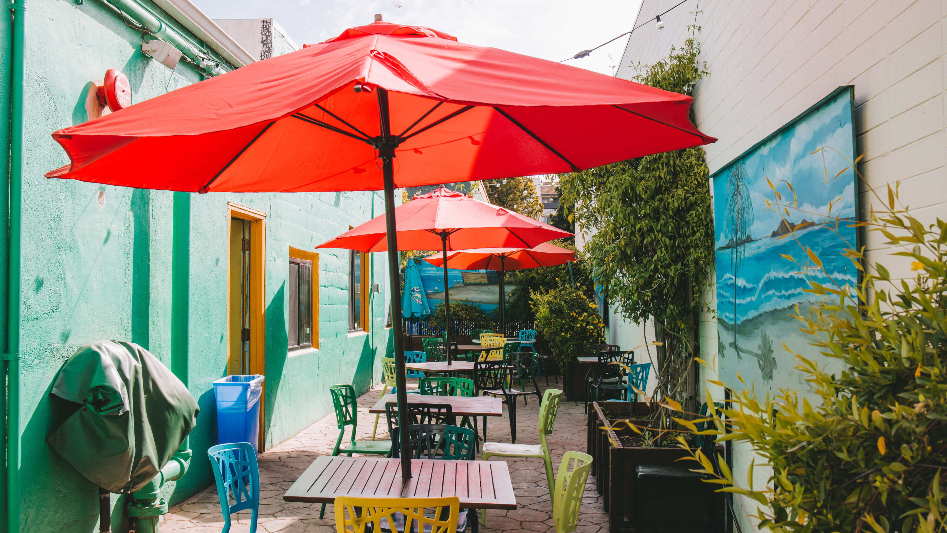 outdoor patio with colorful furniture and umbrellas above each table