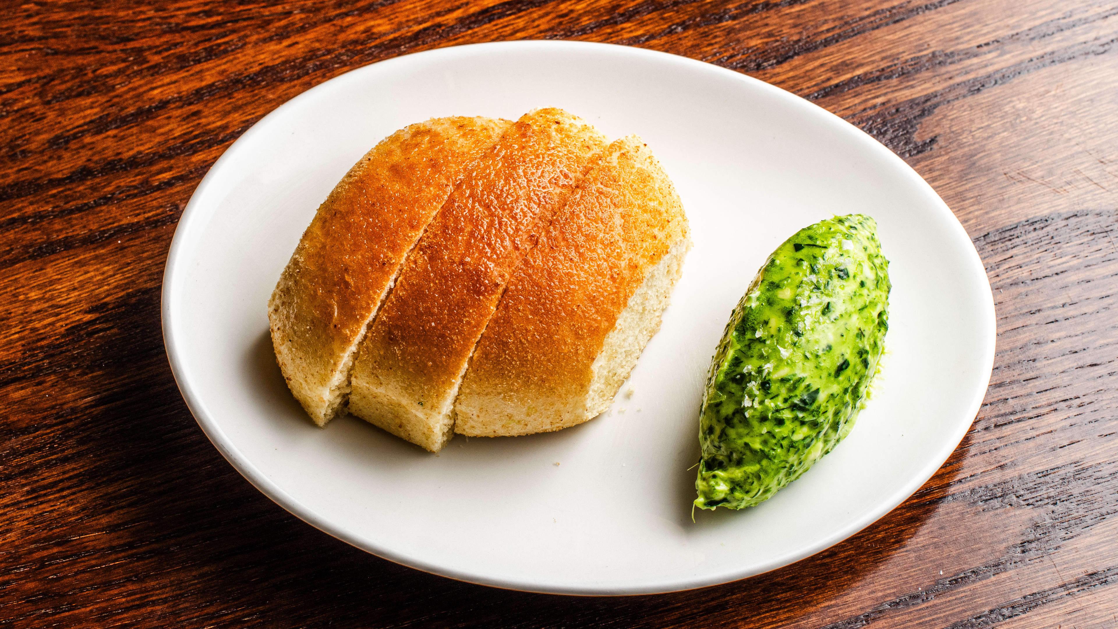 Three slices of the pandesal bread with a quenelle of chive butter from Donia.