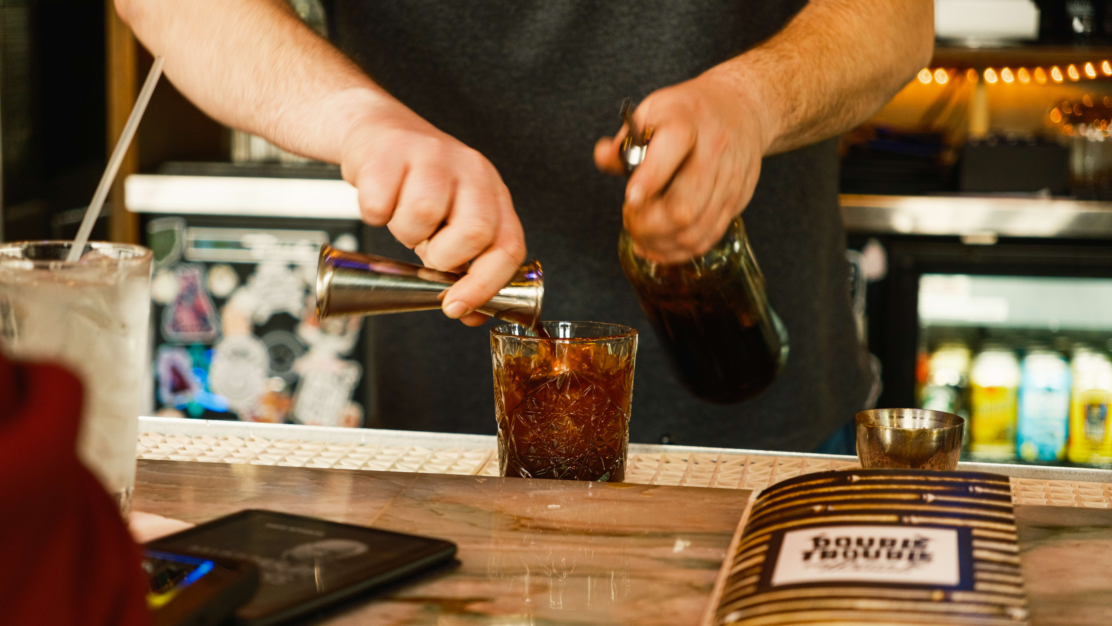 A bartender making the Betty Whizzle cocktail at Double Trouble.