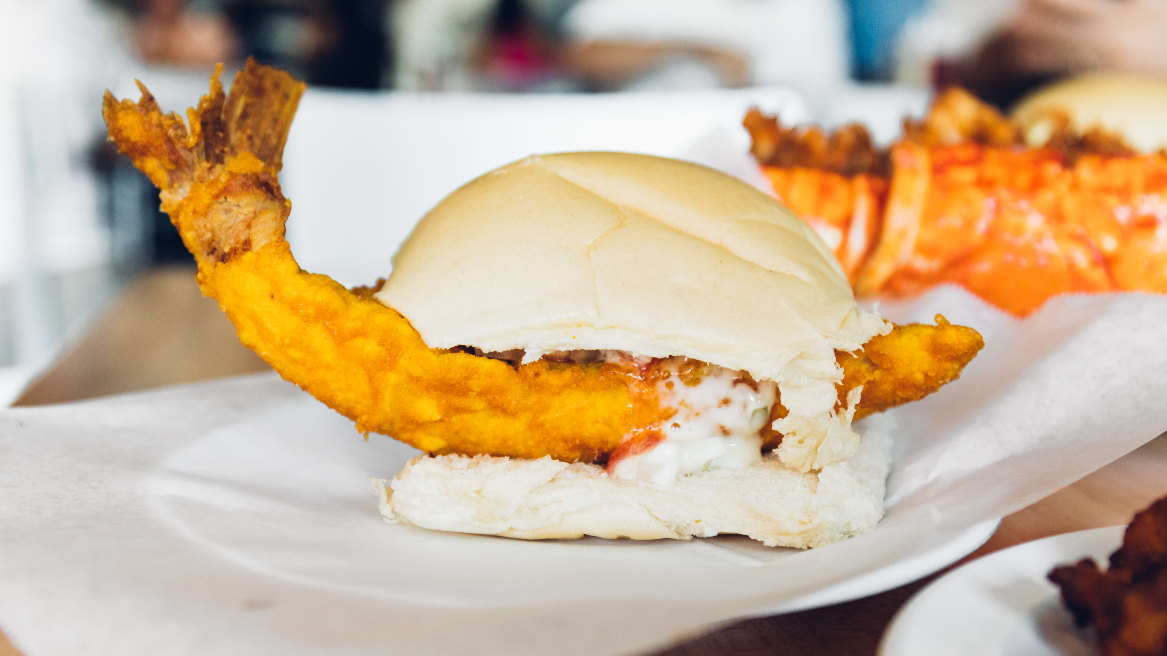 bun with deep fried shrimp between it and mayo
