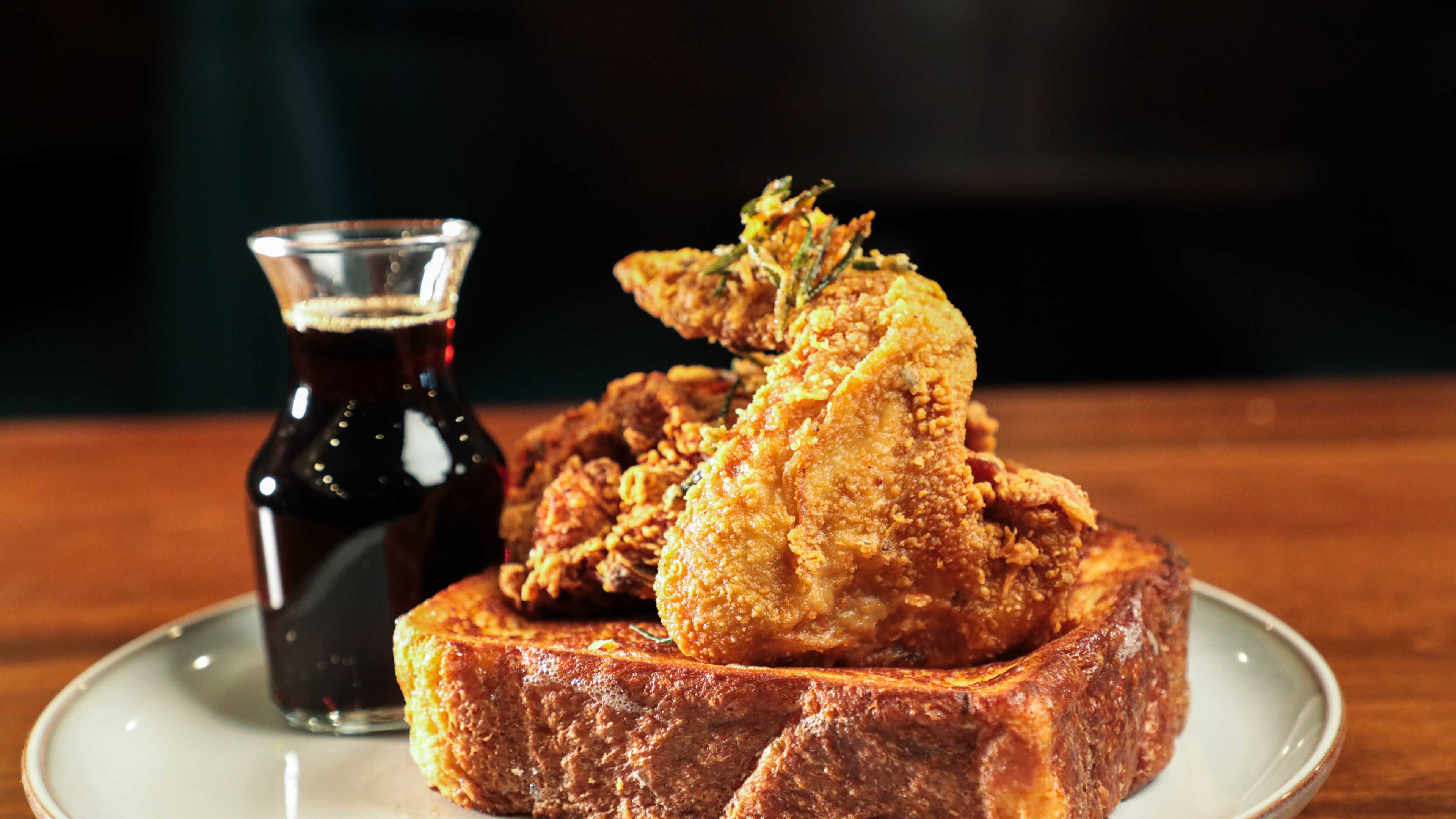 rosemary fried chicken on top of french toast with syrup on side