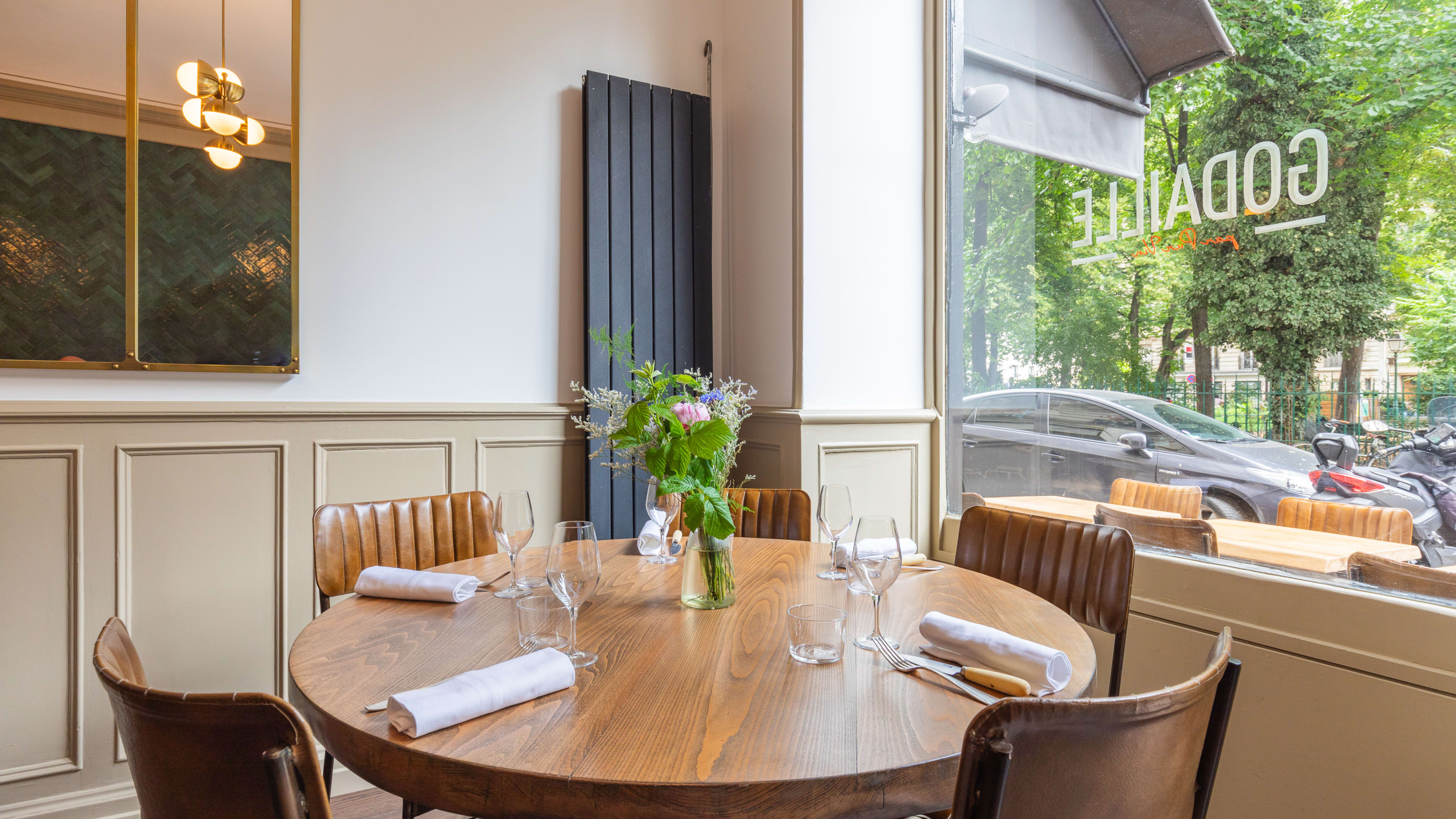 A corner table right in front of a big window inside Godaille, a restaurant in Paris