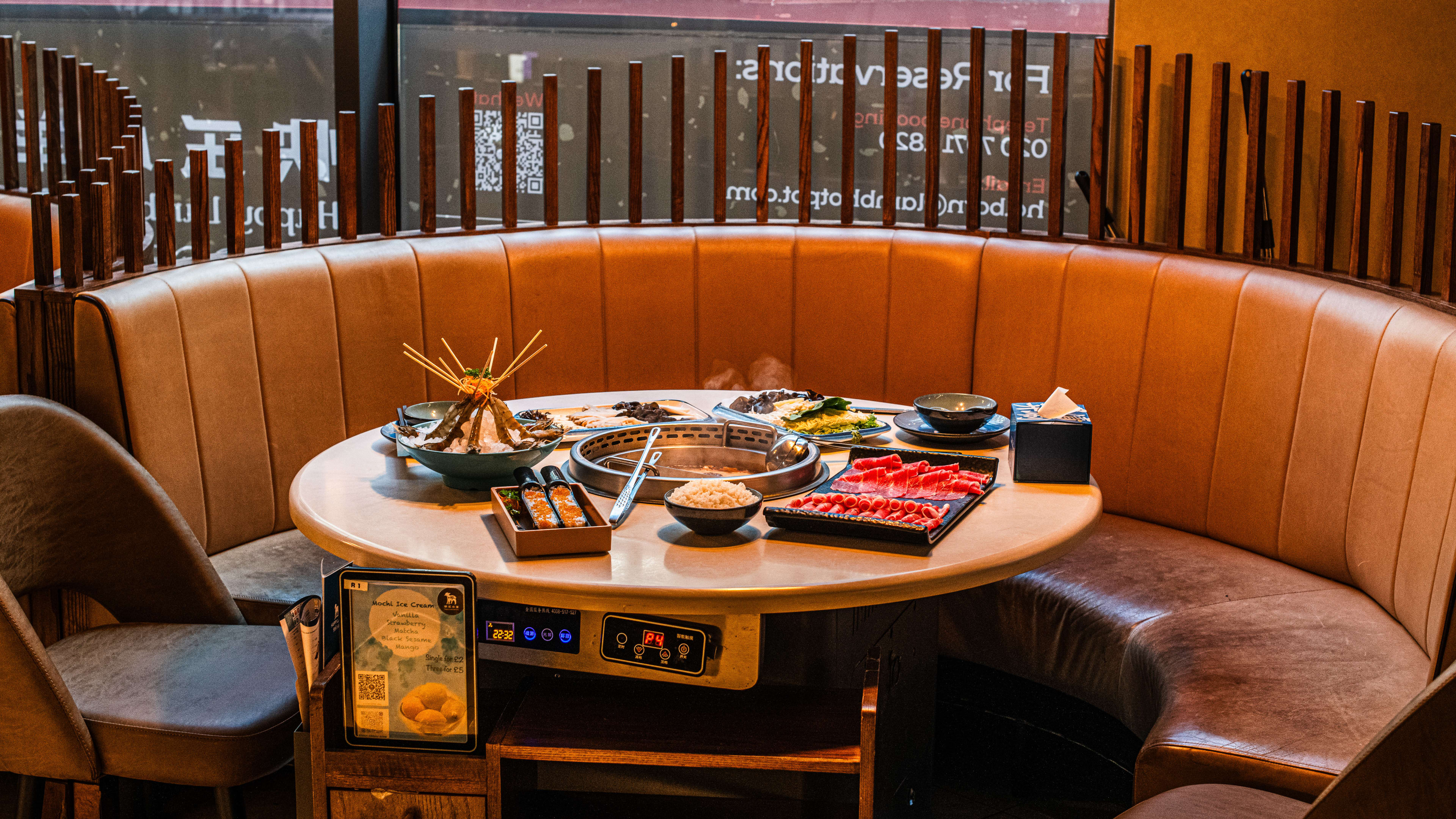 Round table with built in hot pot with dual flavour hot pot with nourishing marrow chicken broth and spicy marrow chicken broth. Plus Beef & Lamb Platter, fish balls with tobiko, king prawns, small mushroom platter, and small vegetables and noodles platter. Plus rice on the side.