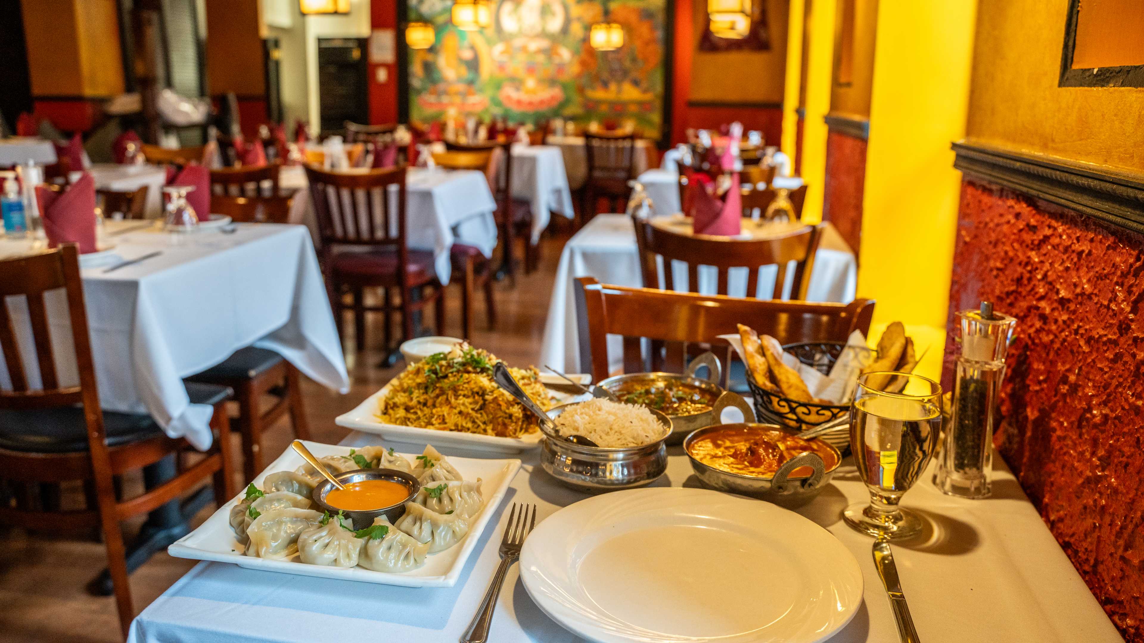food spread of indian and nepali dishes in ornate dining room