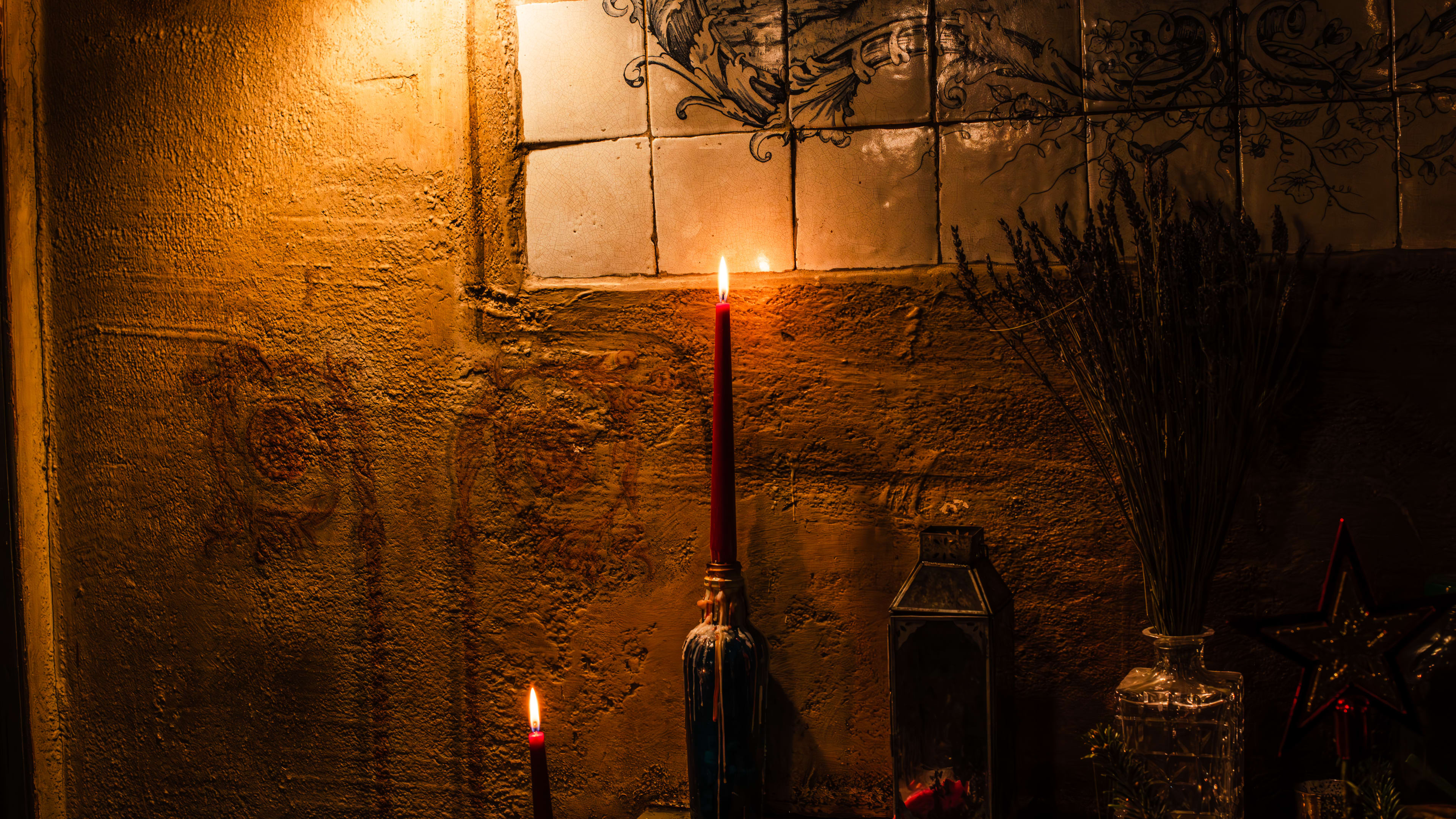 A candlelit shelf inside of The Holy Tavern.