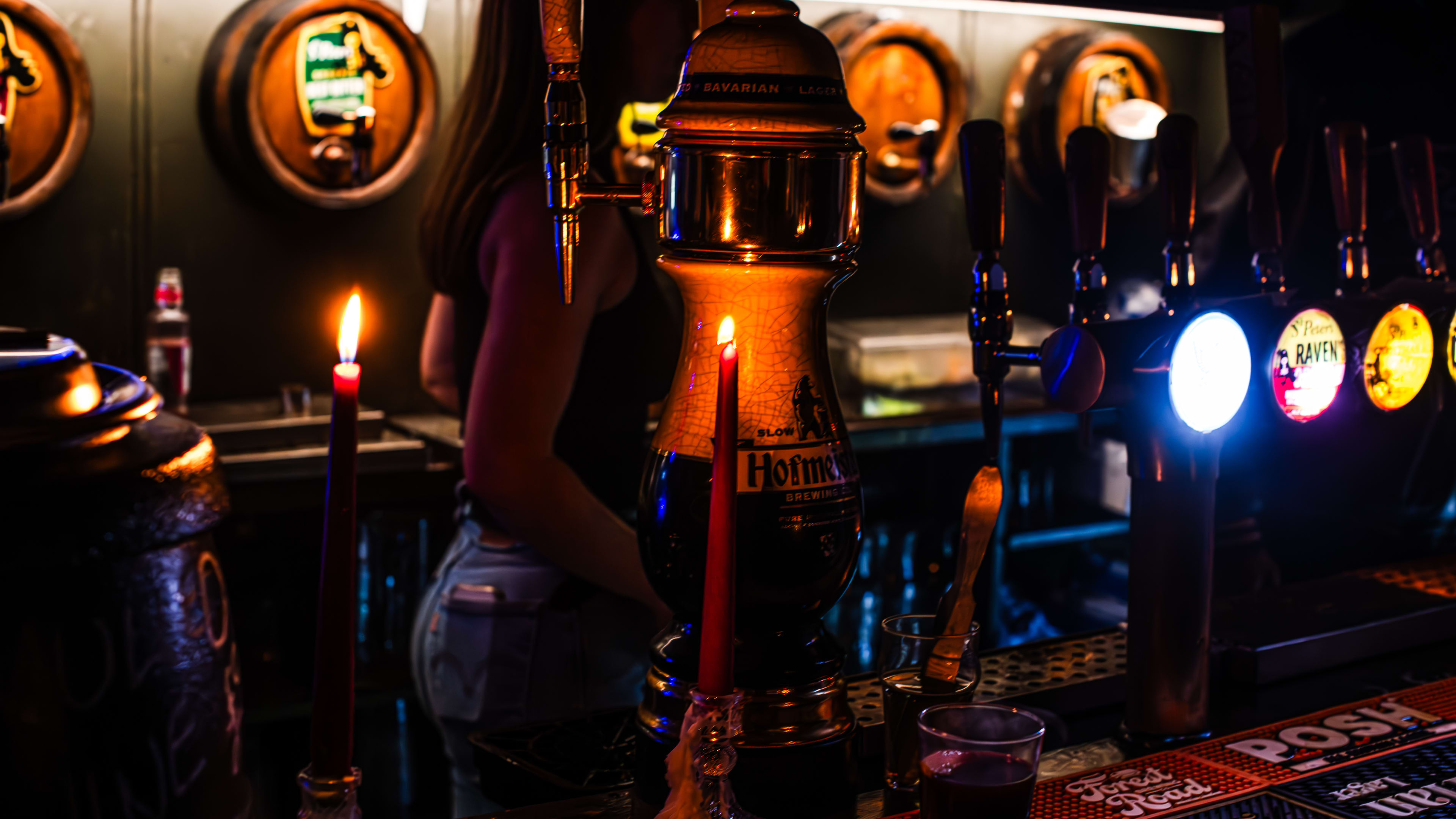 A pint of Guinness on a candlelit bar.