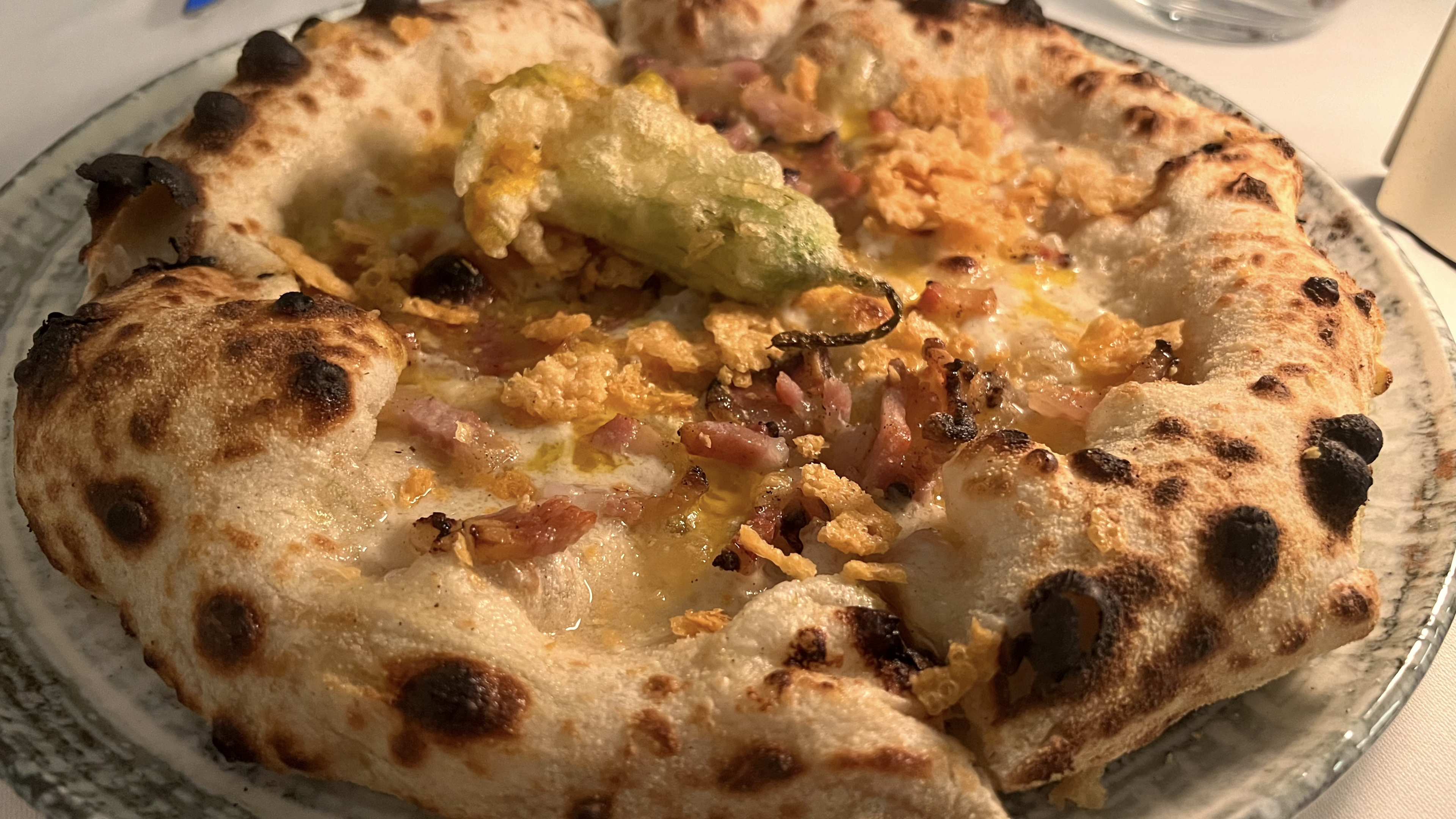 A fluffy pizza on a glass plate.