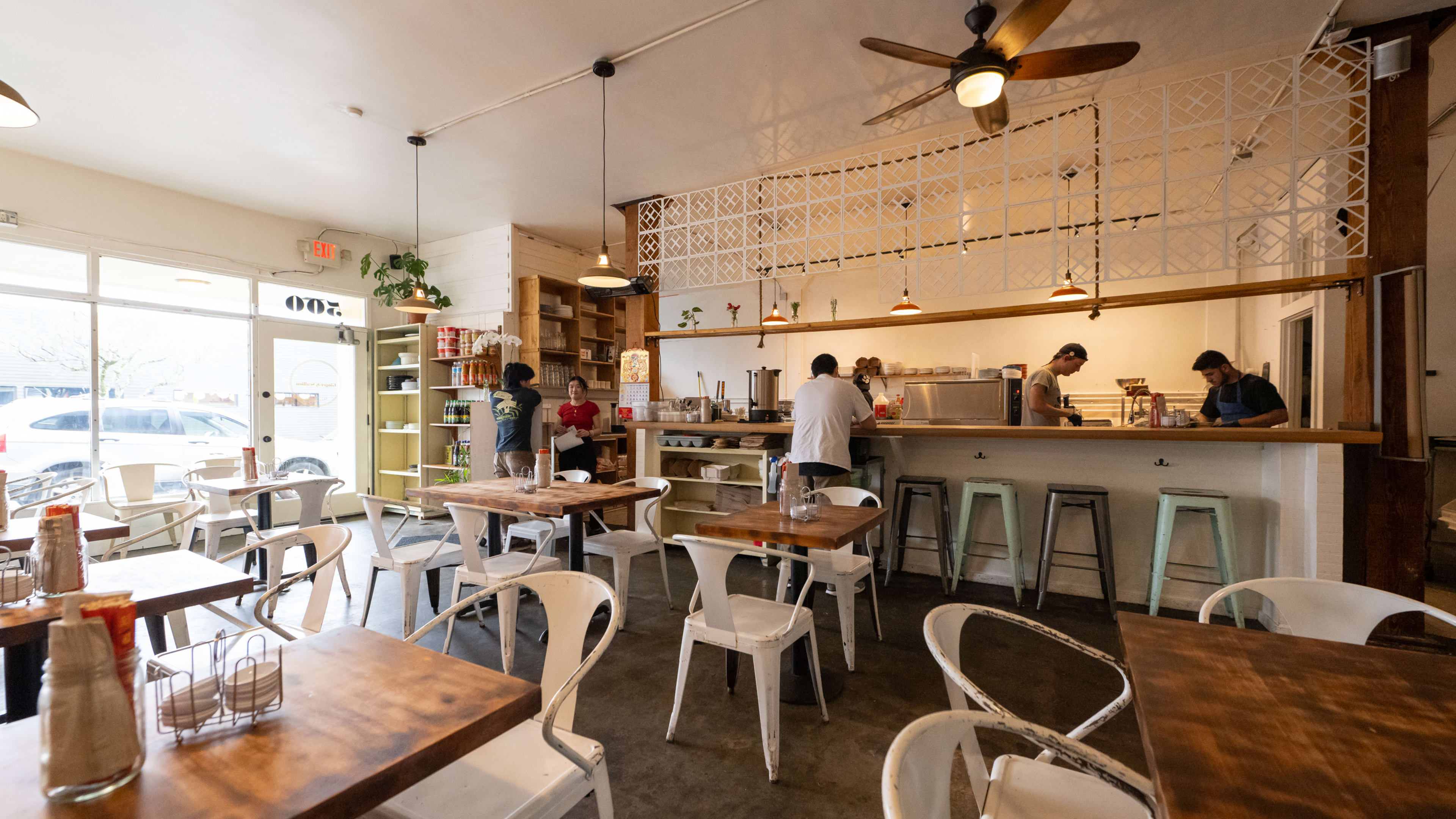 Small dining room with wooden tables and white metal chairs