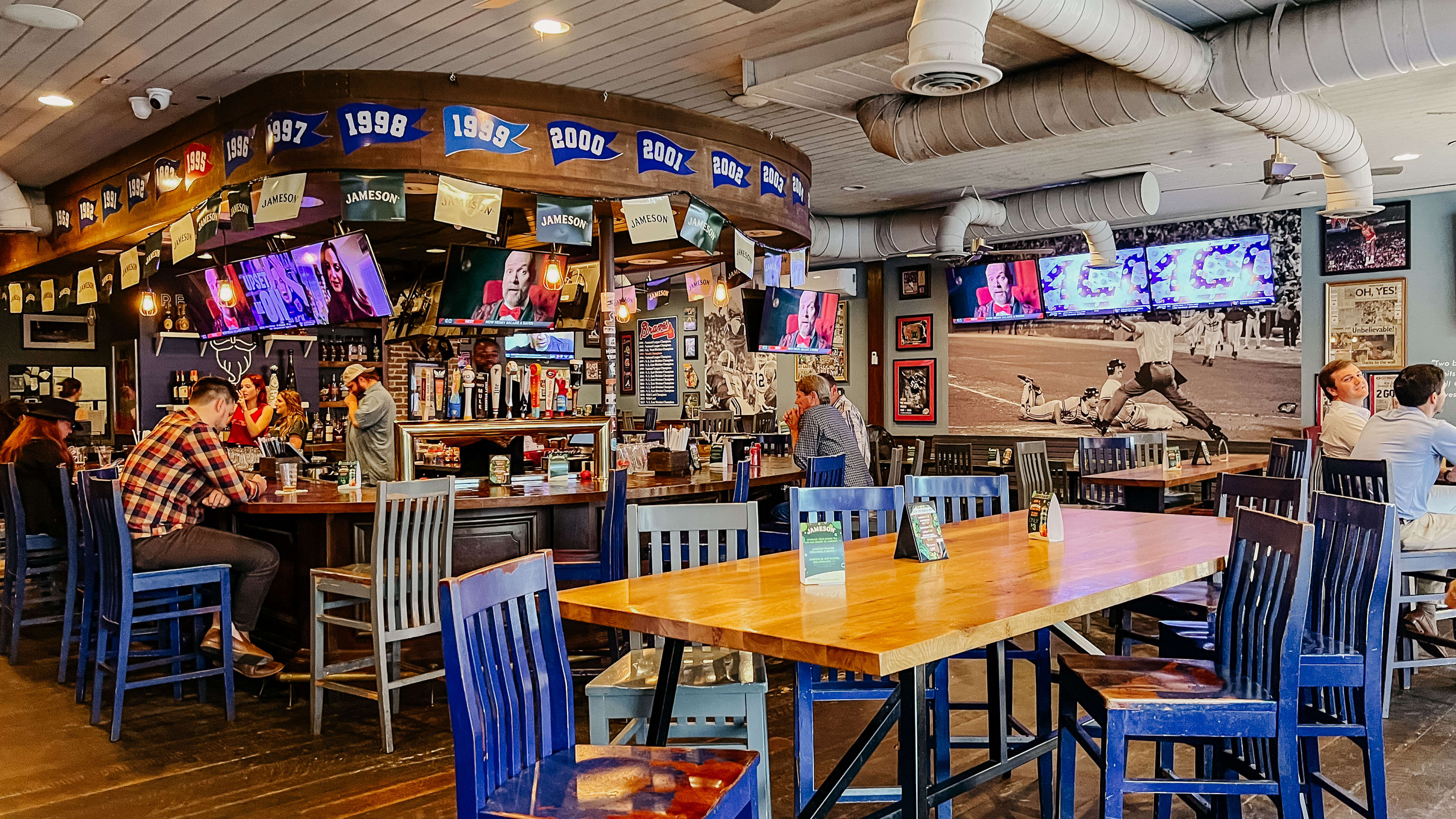 A bar and tables with blue chairs.