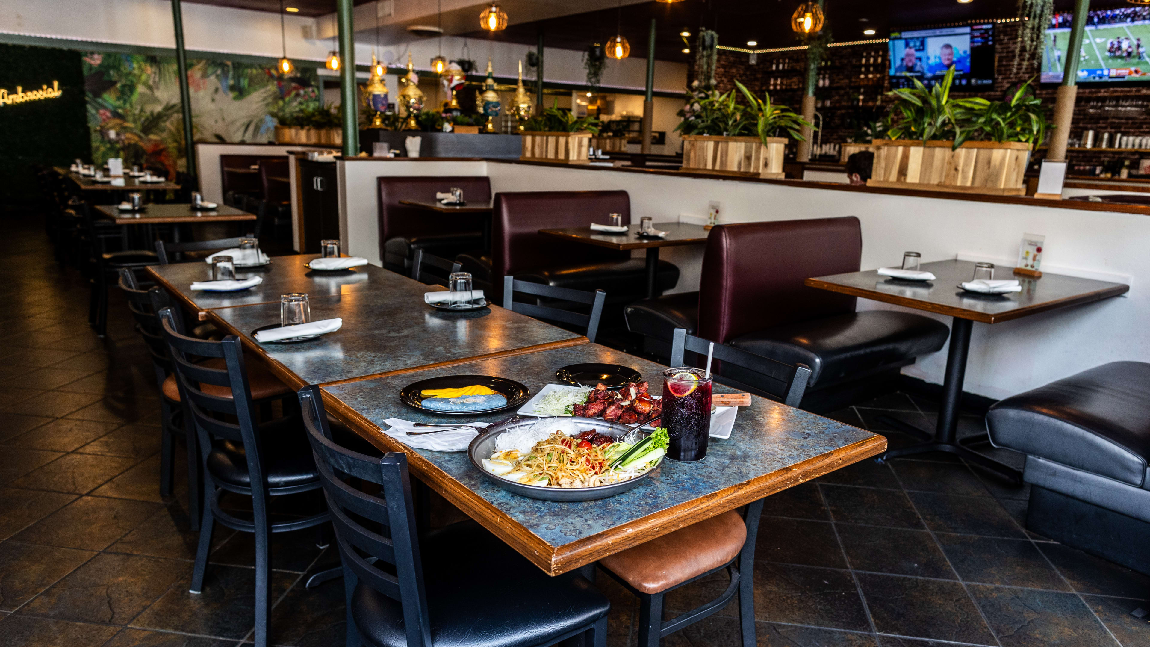 a variety of dishes set on a table inside Khon Thai's large dining room.