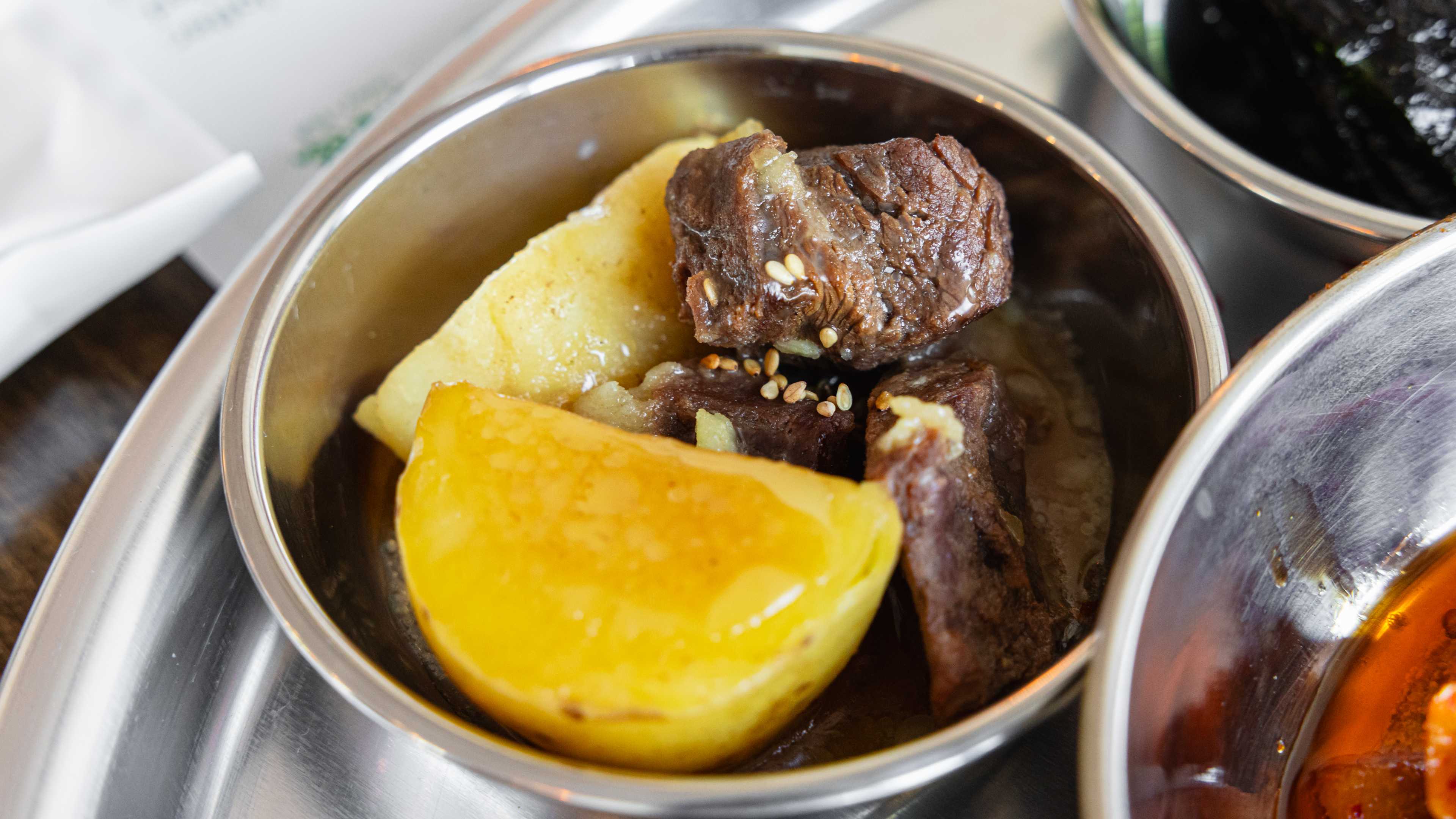 A small bowl of beef and potatoes.