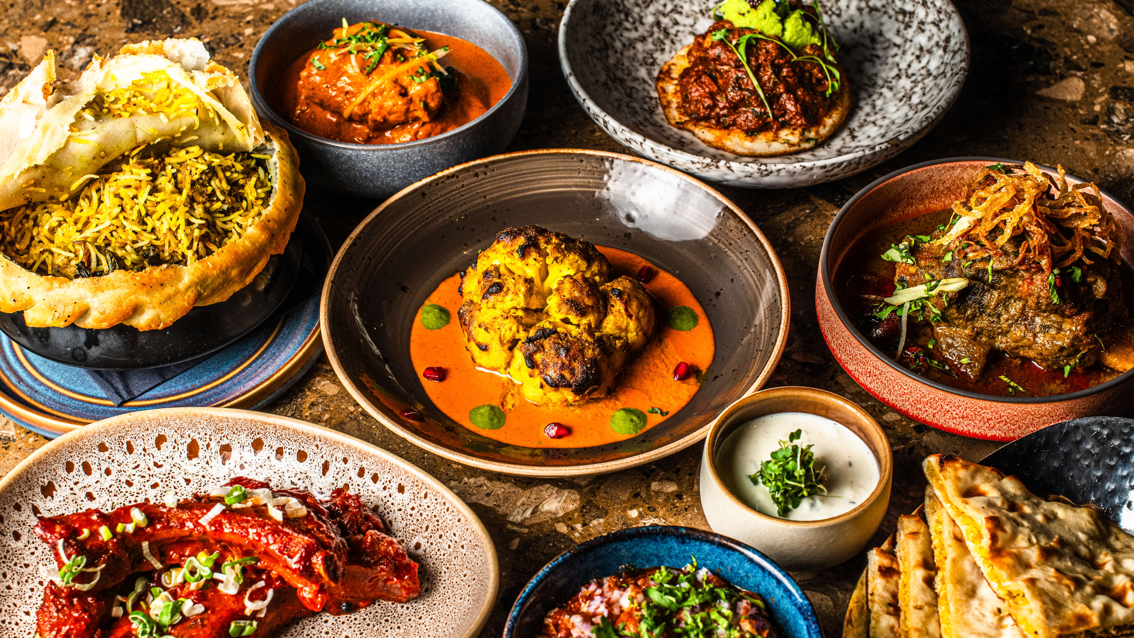 A variety of dishes from Kokum served on organically shaped ceramic dishware.