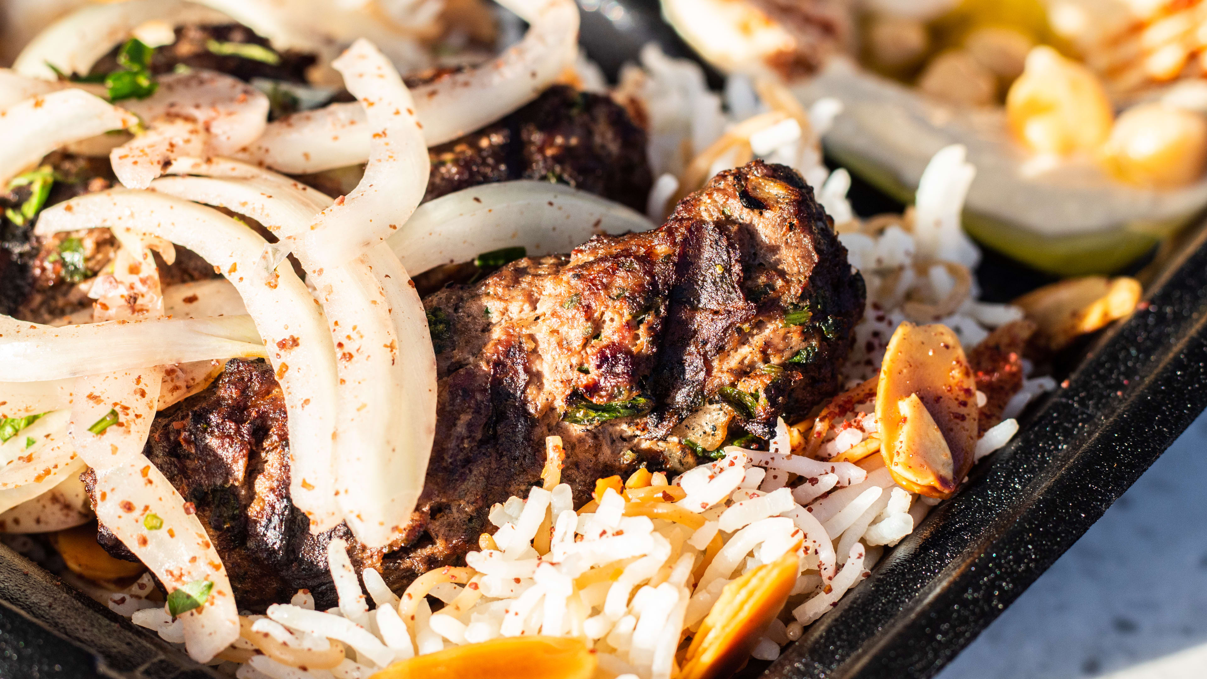 A close shot of a takeout box filled with rice and meat.