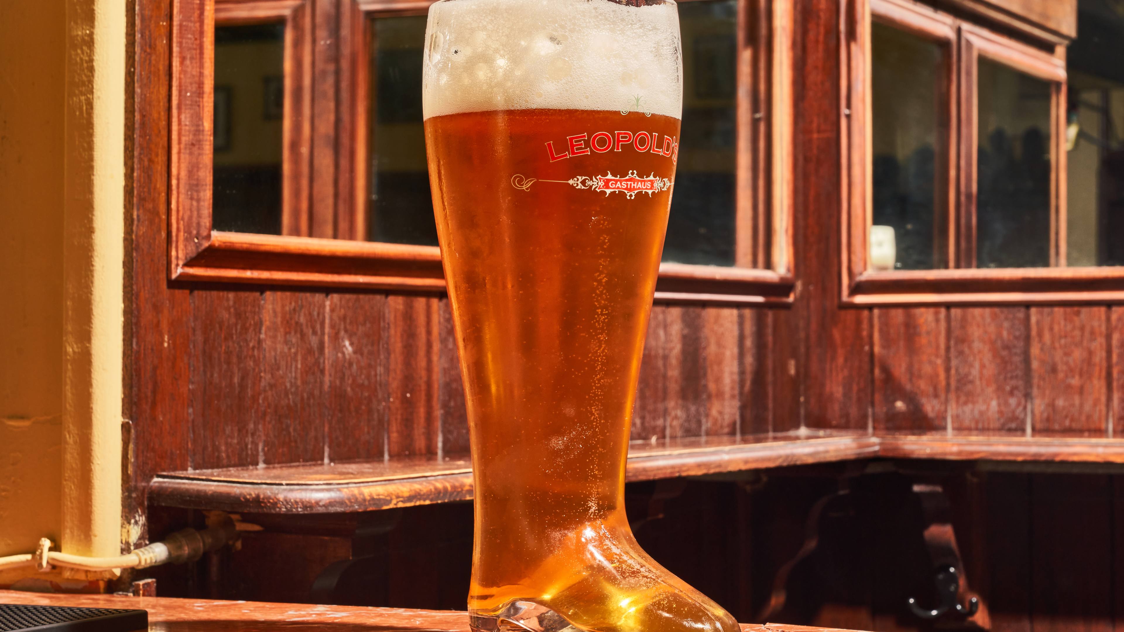 massive glass boot filled with beer in bar that looks like cabin