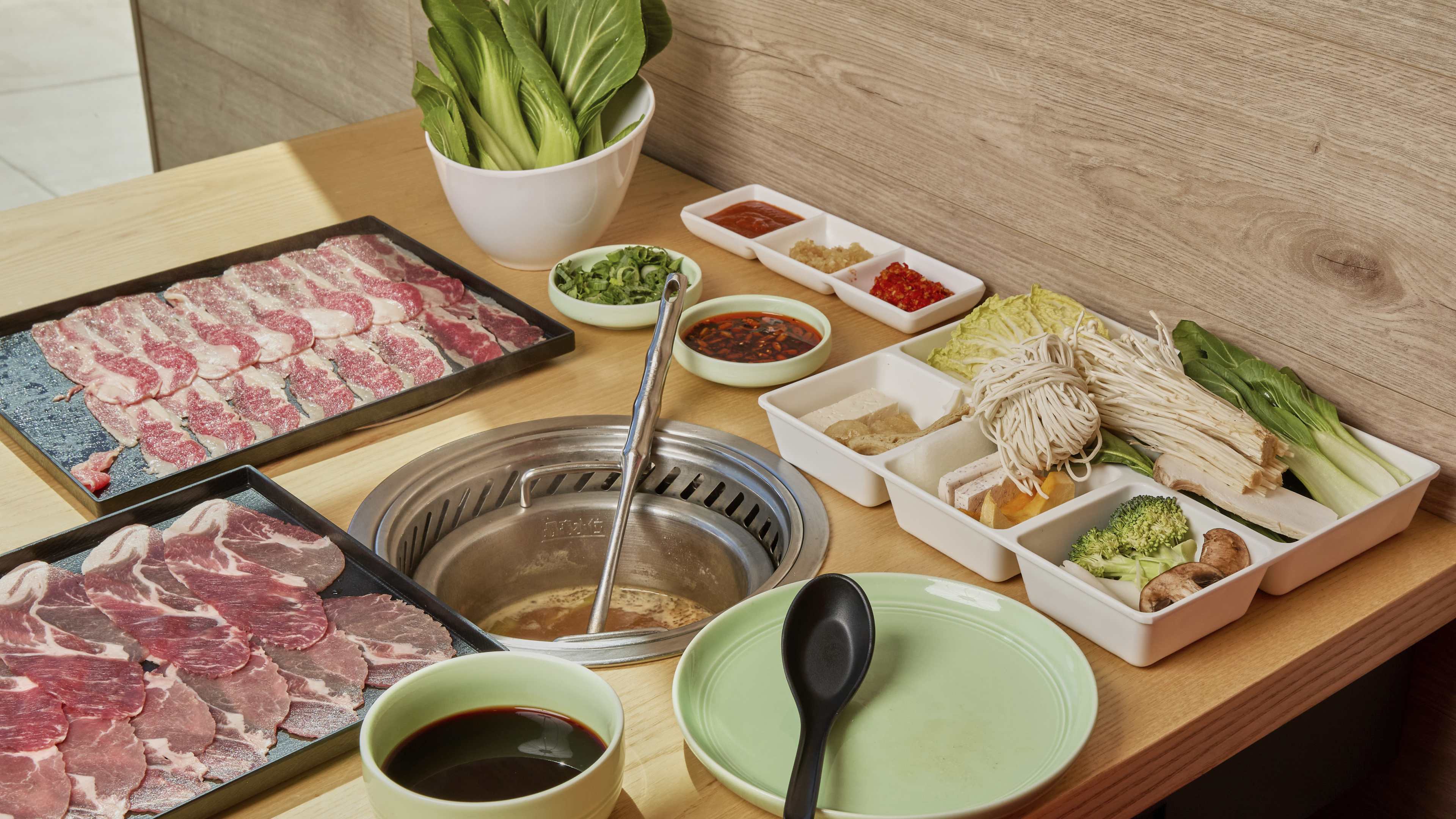 A spread of meat and sides at Mumu Hot Pot