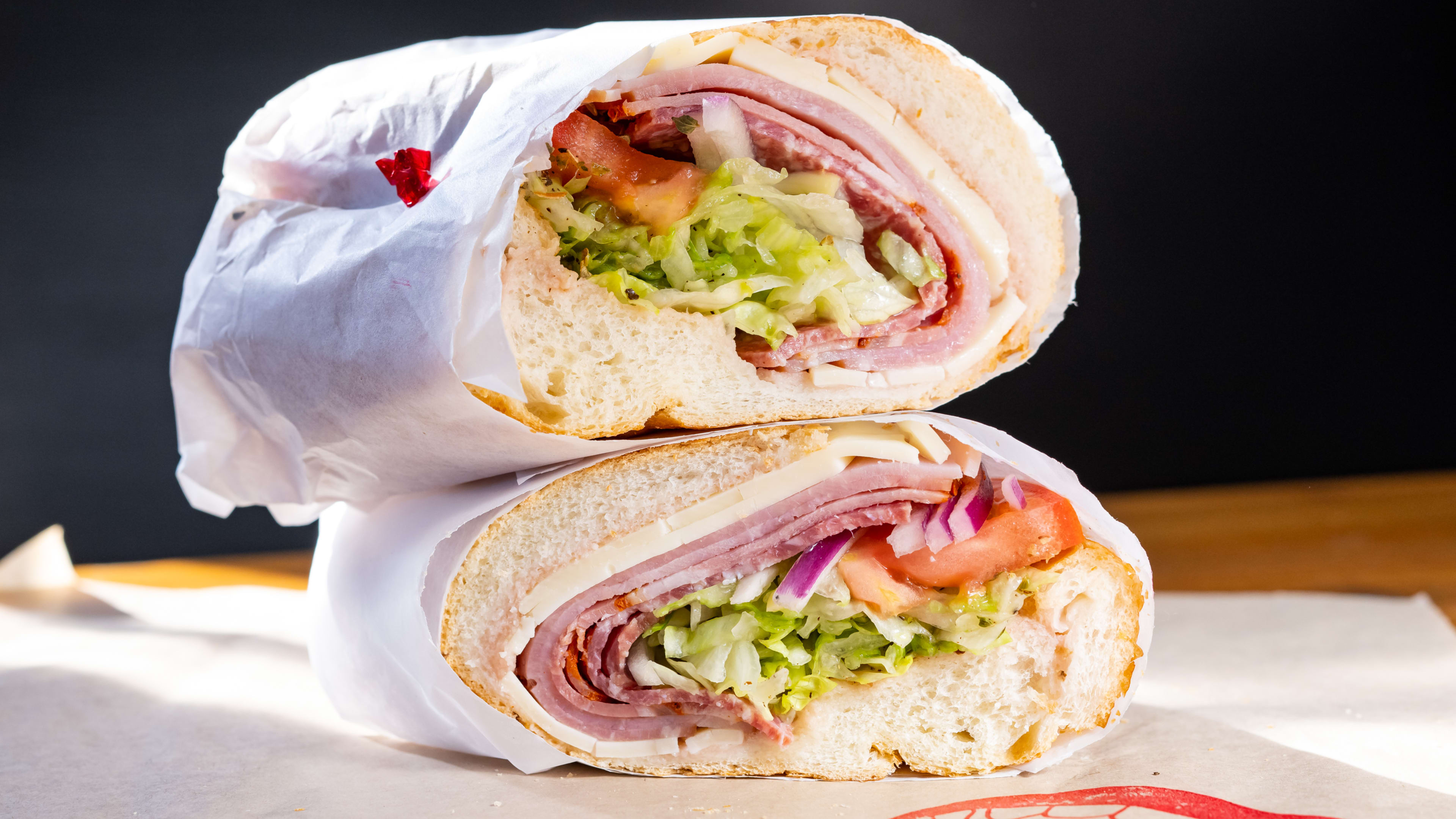 Italian sub with ham, cheese, lettuce, and tomatoes