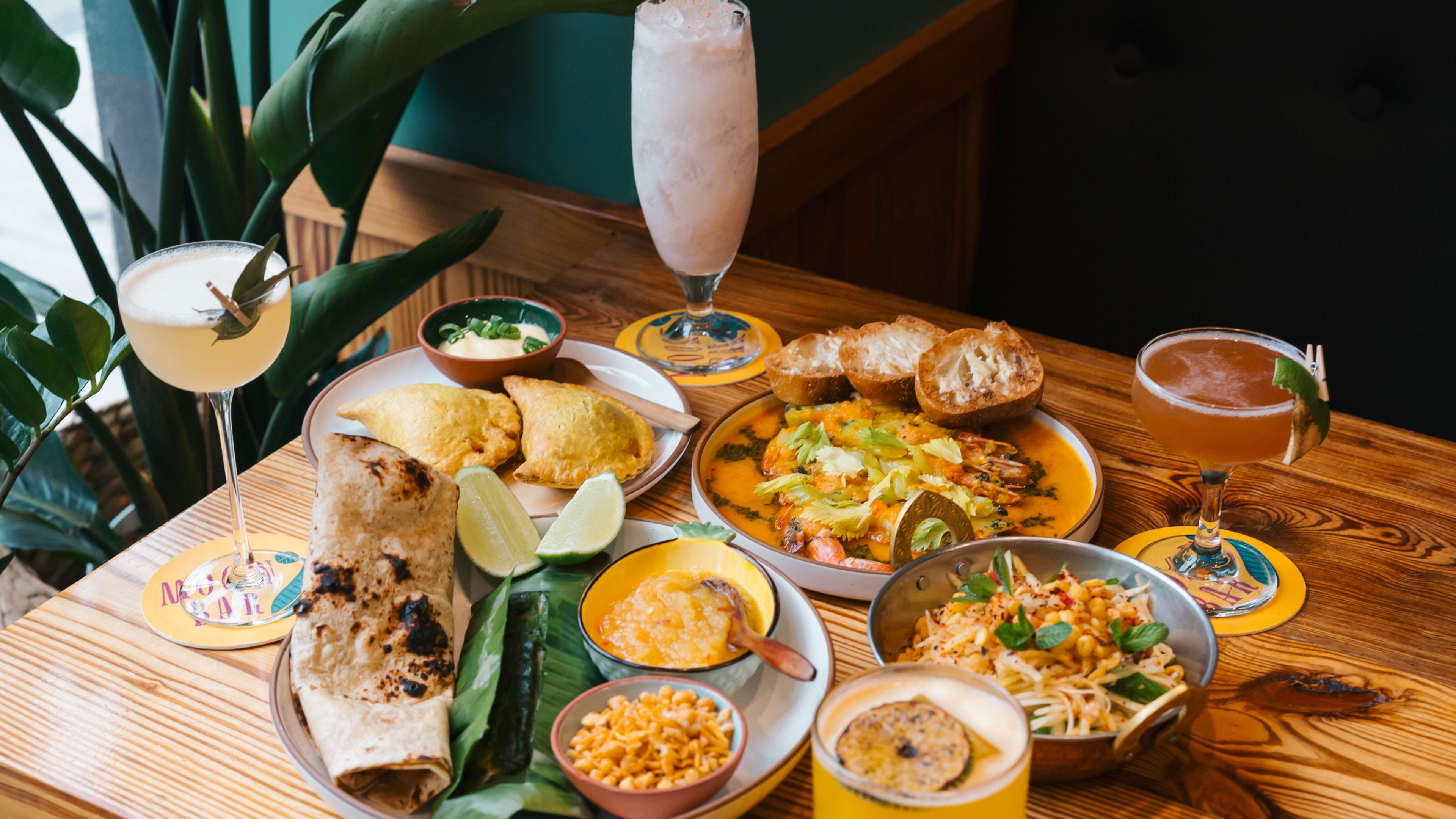 Spread of Thai dishes and colorful cocktails at Moon Bar