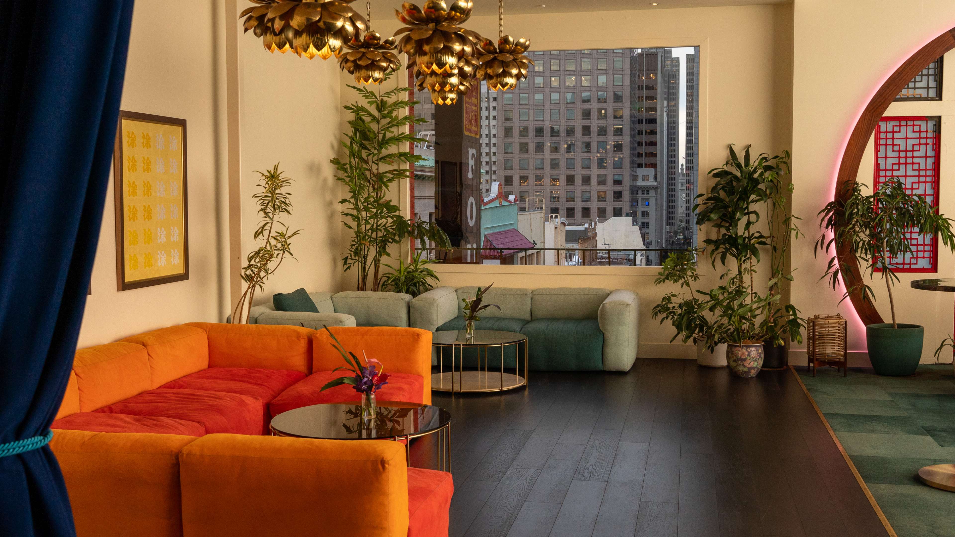 bar with brightly colored velvet couches and modern golden light fixtures